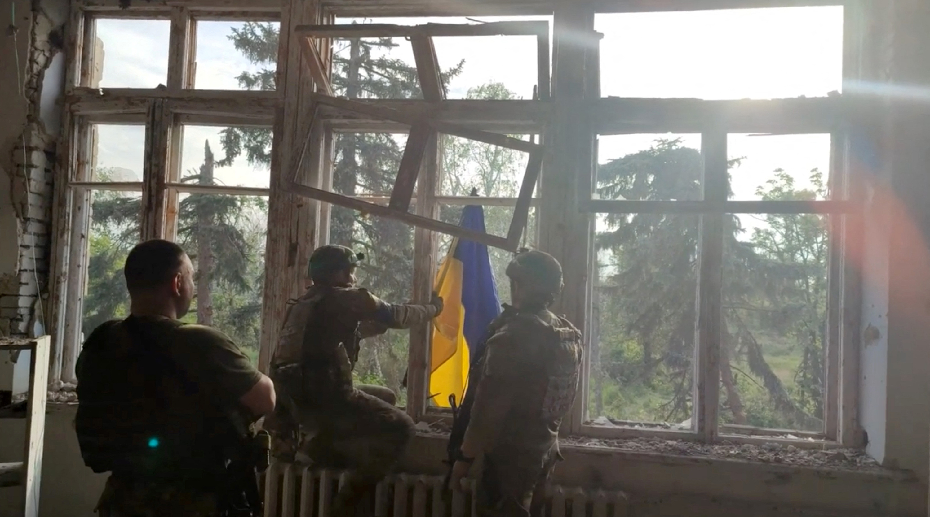 Ukrainian soldiers raise a Ukrainian flag, during an operation that claims to liberate the village of Blahodatne, in this screengrab taken from a handout video released on June 11. 