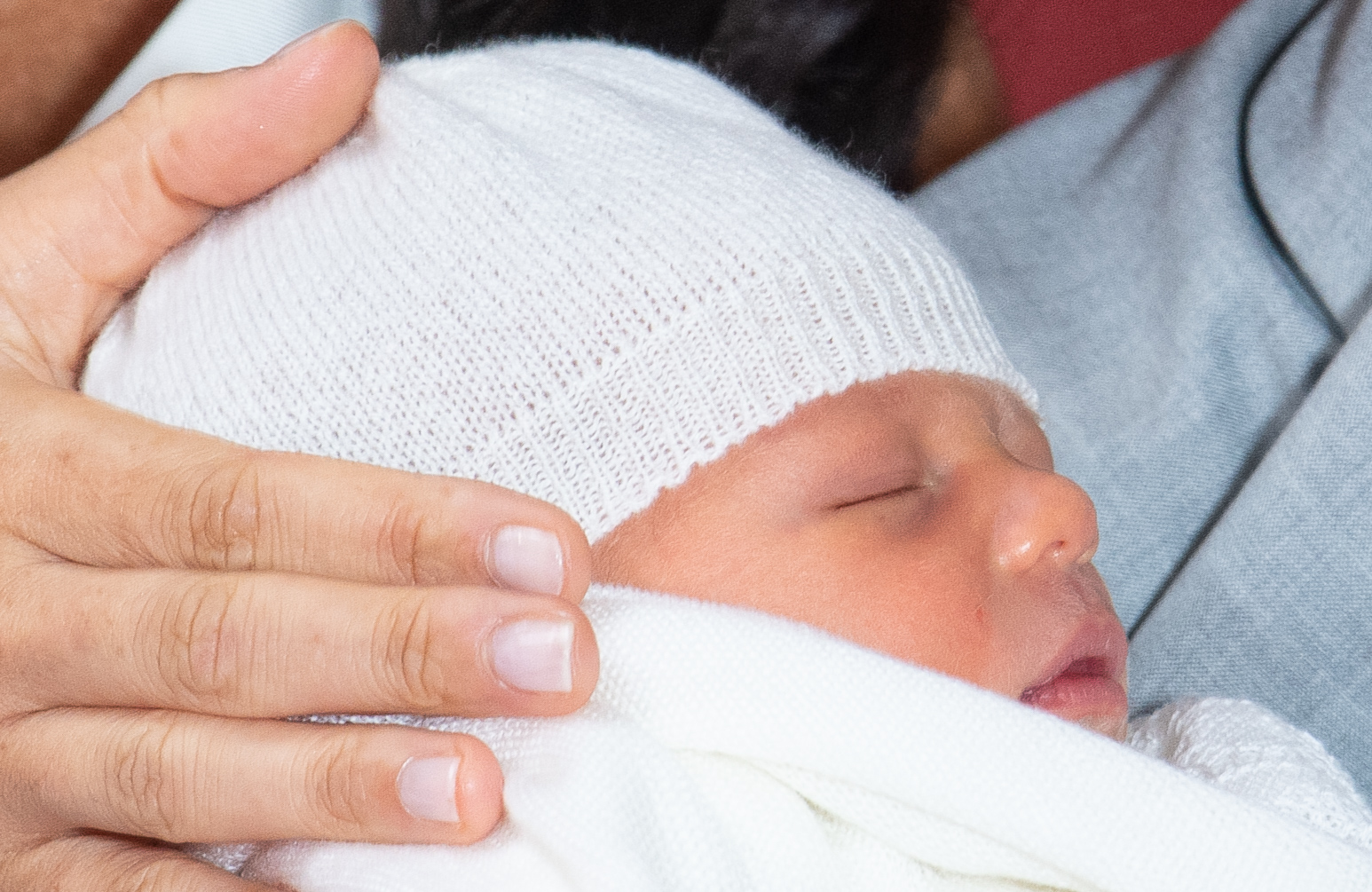 Meghan, Duchess of Sussex, places her hand on the baby's head.