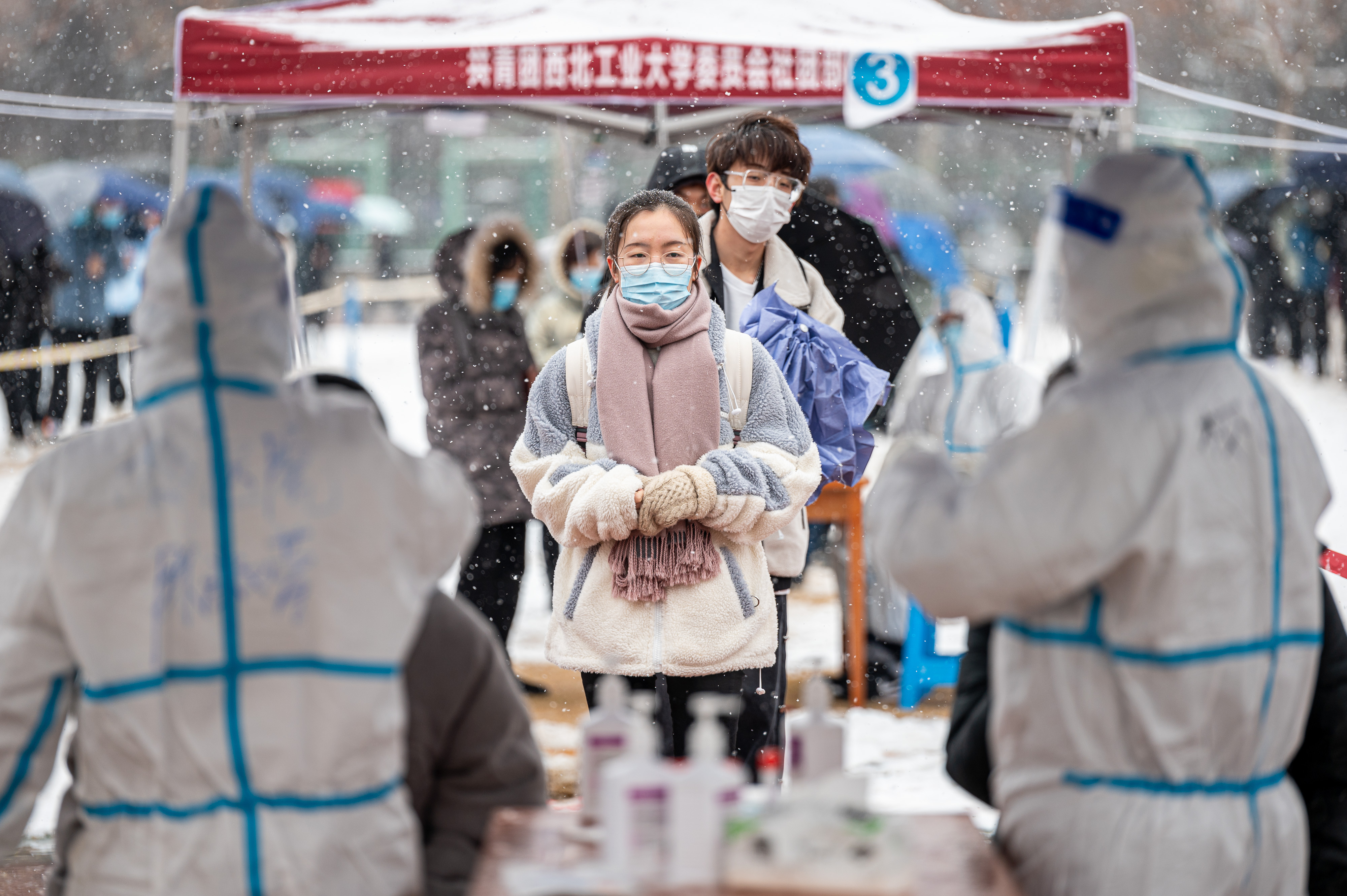 Students and teachers line up for a COVID-19 nucleic acid test at Northwestern Polytechnic University during a snowfall on December 25, 2021 in Xi'an, Shaanxi province, China. 