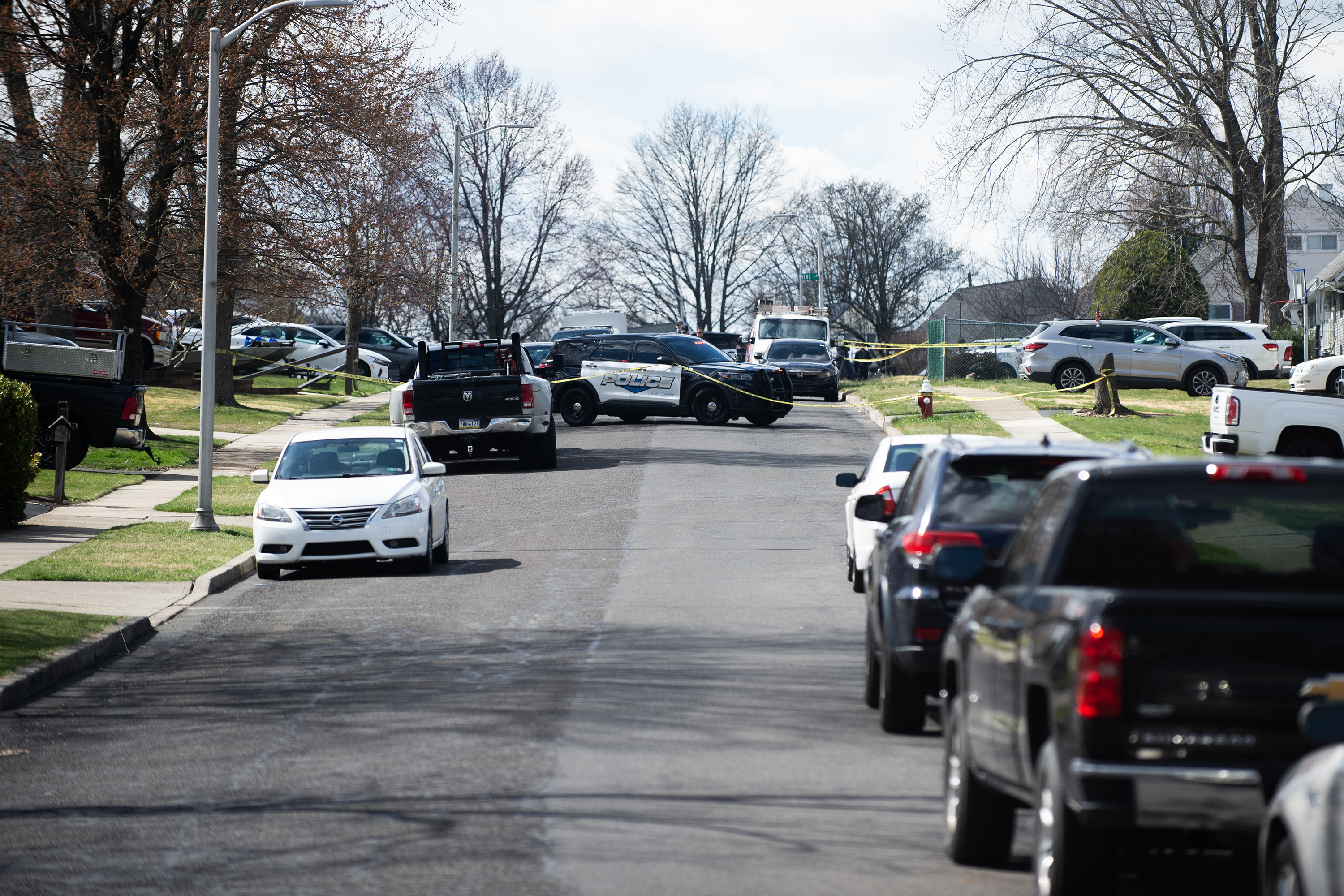 Police officers from the Falls Township Police Department tape off and inspect the scene after a suspect shot and killed three people in Levittown, Pennsylvania, on March 16.