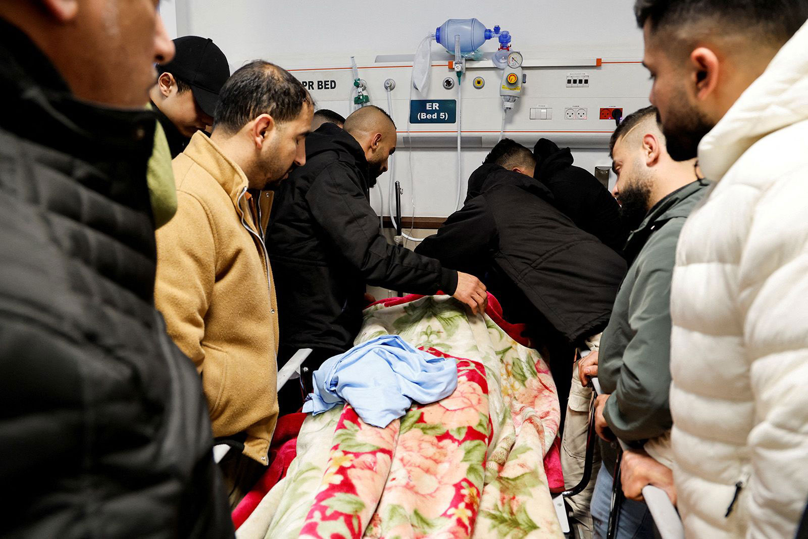Mourners react next to the body of a Palestinian killed in the raid January 30.