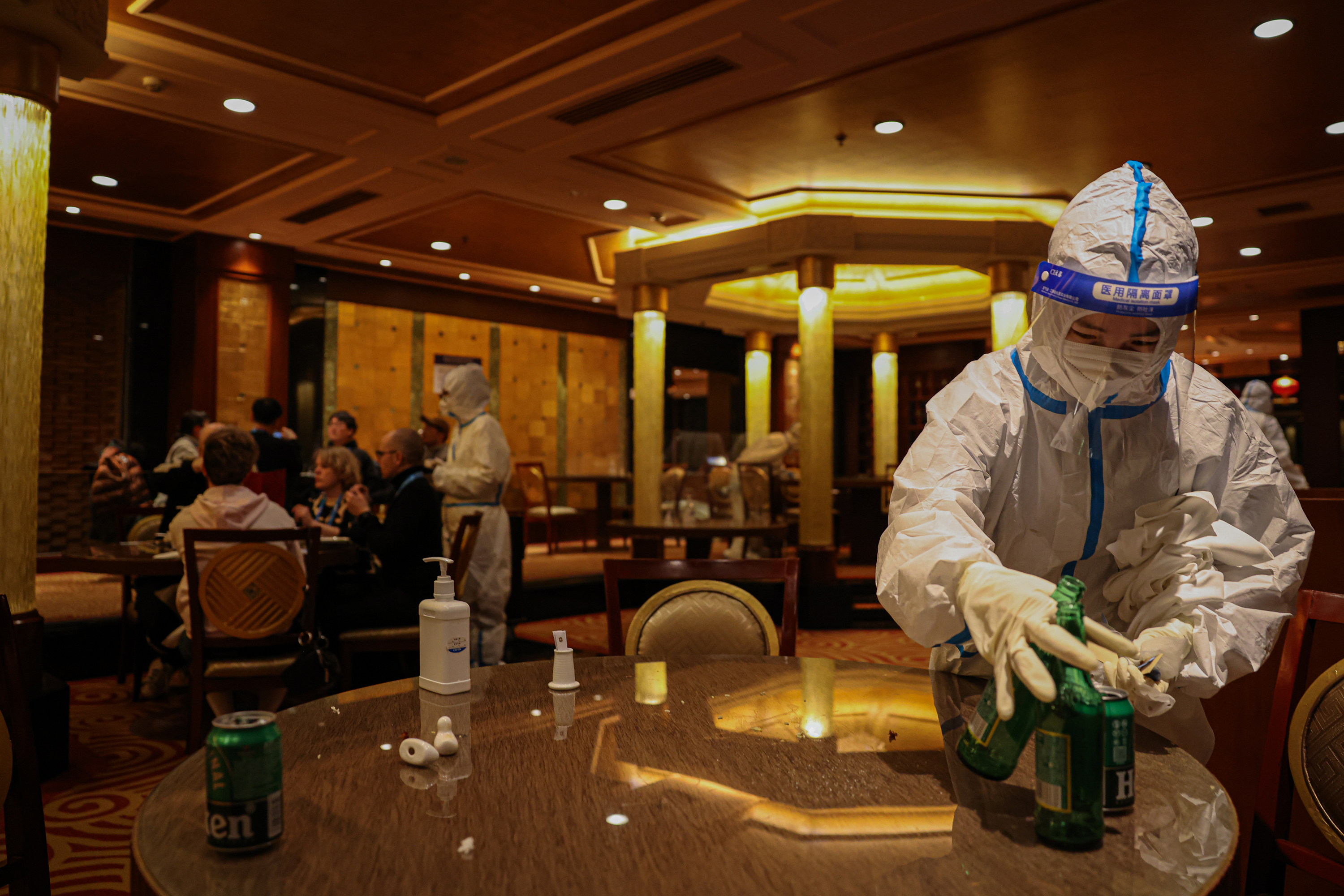Workers in hazmat suits work in a hotel restaurant, which is part of the Beijing 2022 Winter Olympics closed-loop system on February 10.