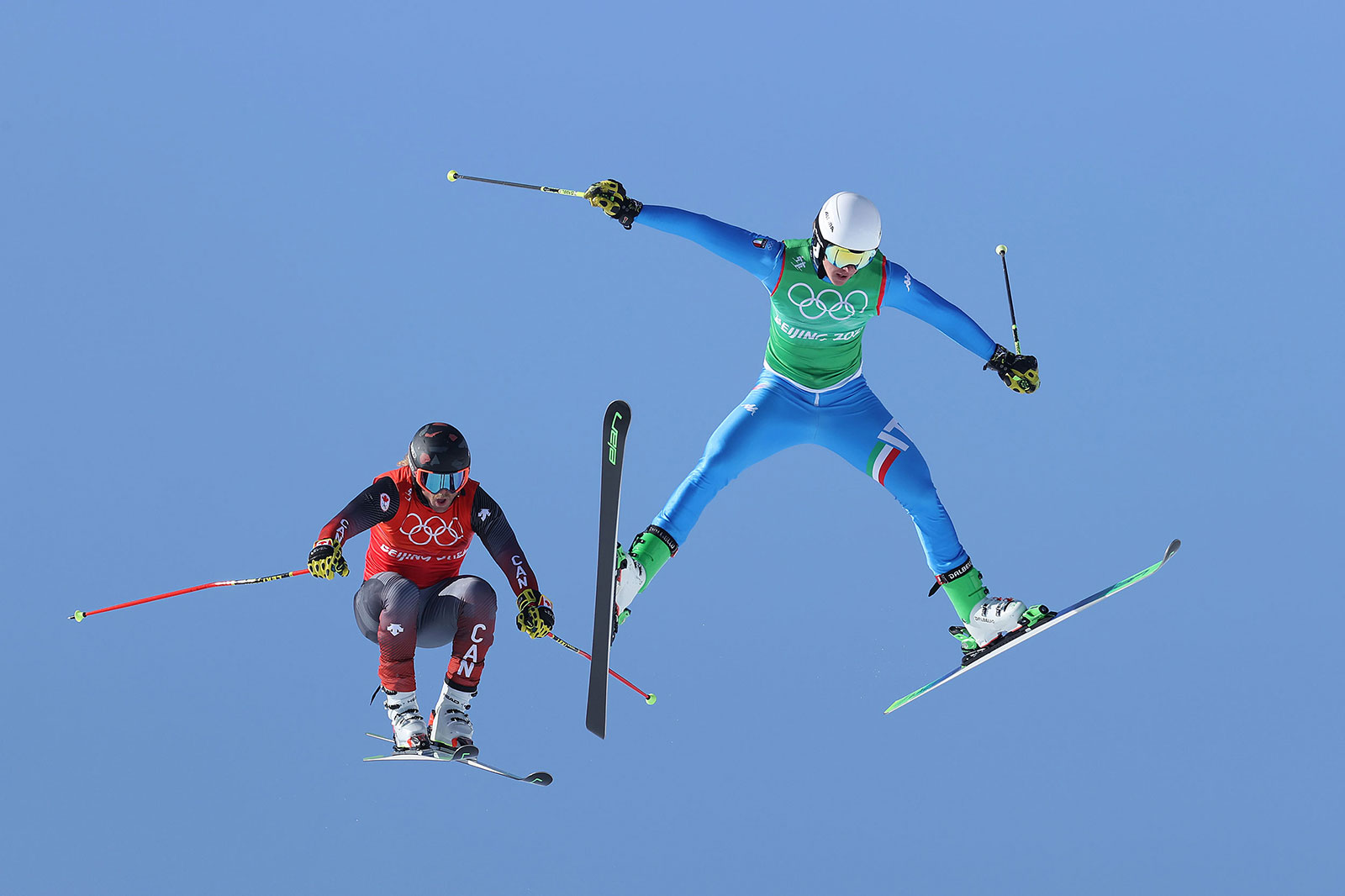 Canada's Brady Leman, left, Italy's Simone Deromedis fly through the air during a ski cross race on February 18.