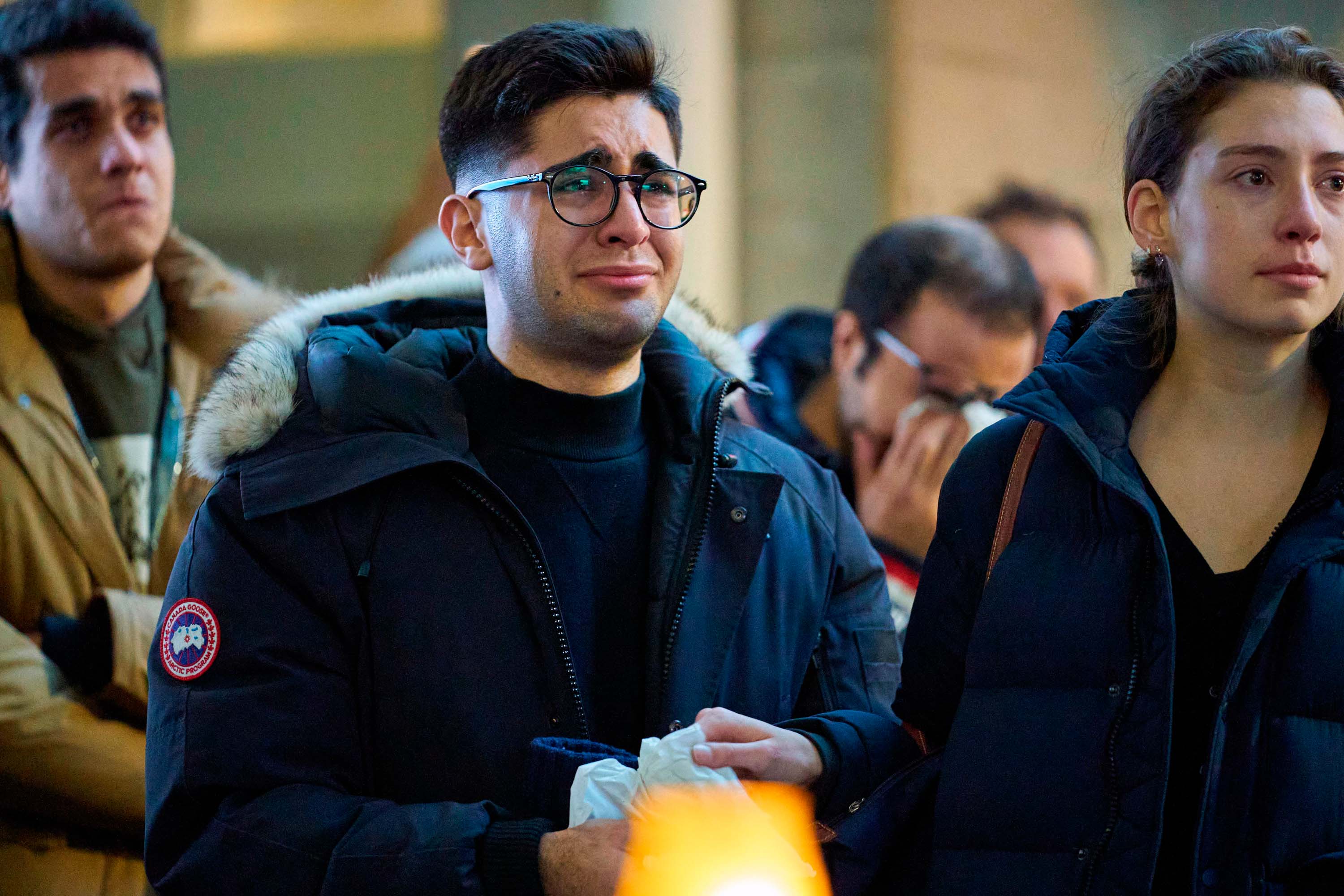 People react during a service at Western University in London, Ontario on January 8 for the four graduate students who were killed in the crash in Iran.