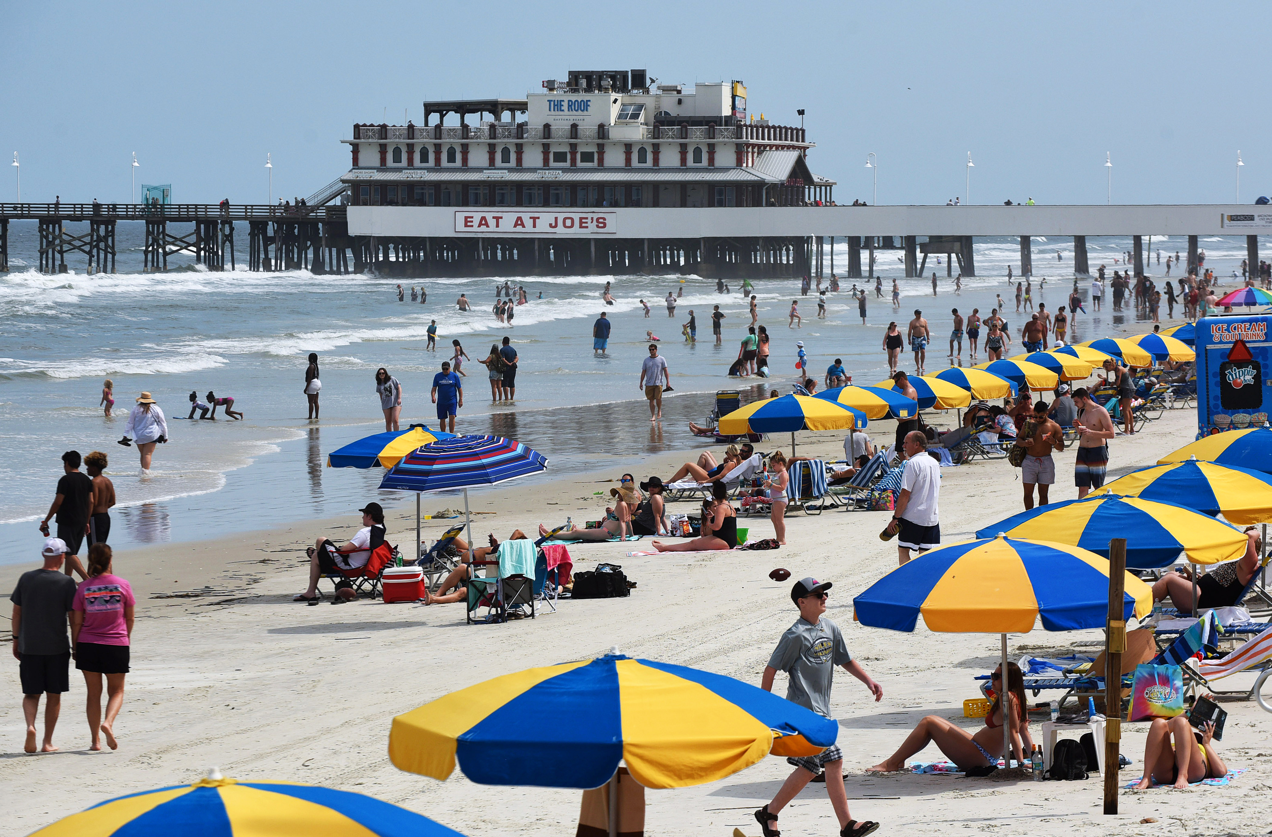 People spend time in the sun near the Daytona Beach fishing pier in Florida, on March 24.