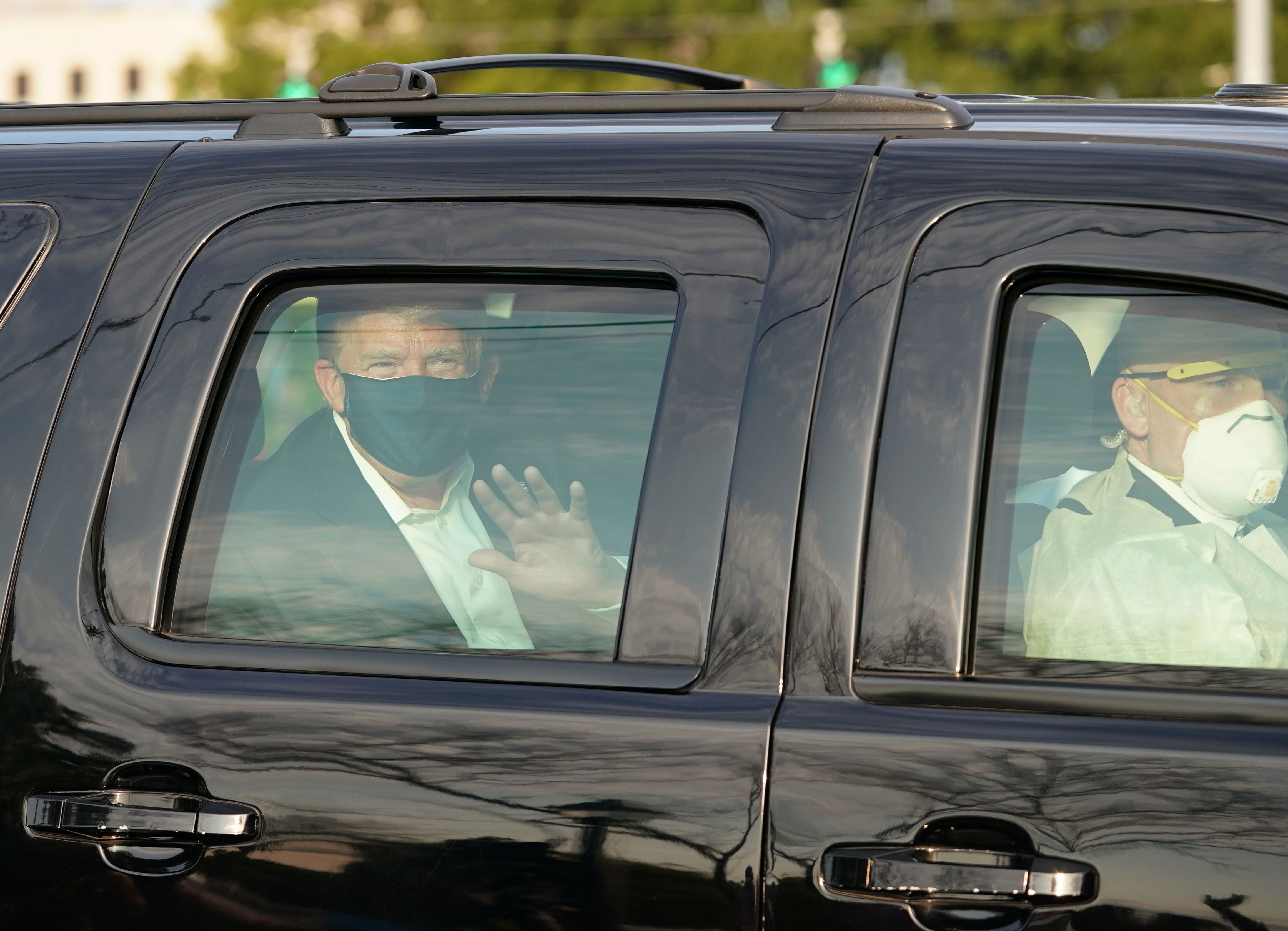 President Donald Trump waves to supporters outside Walter Reed medical center in Bethesda, Maryland, on October 4.