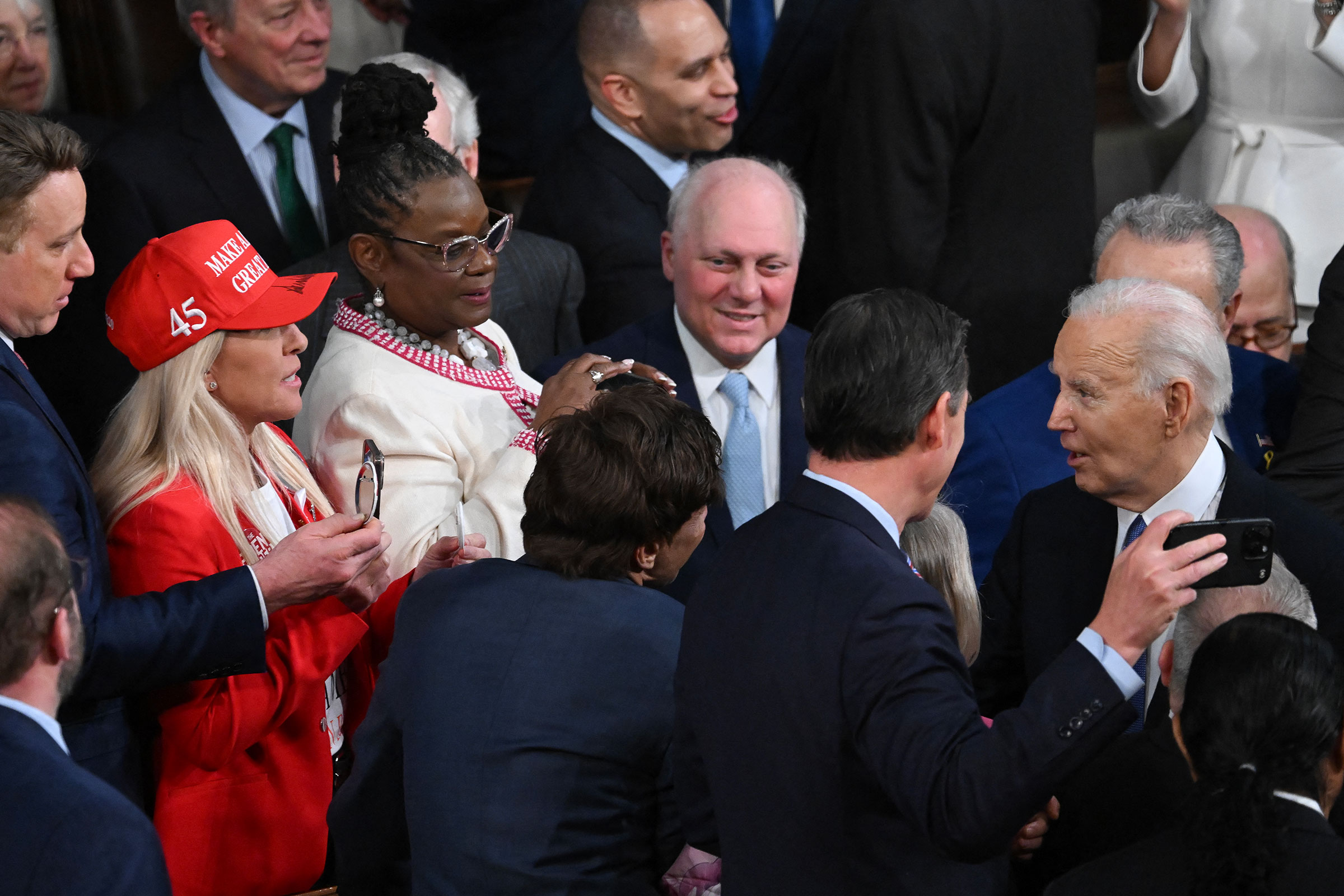 Rep. Marjorie Taylor-Greene hands President Biden a button after he arrives to deliver the State of the Union address.
