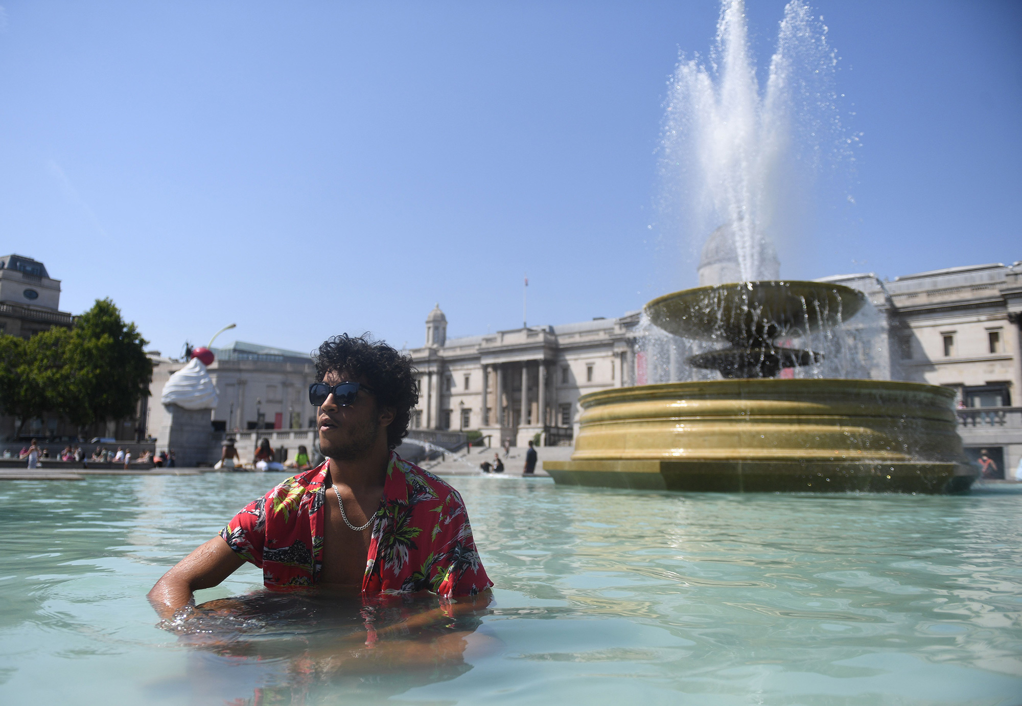 A man cools himself in a fountain at Trafalgar Square in London, England, on Tuesday, July 19.