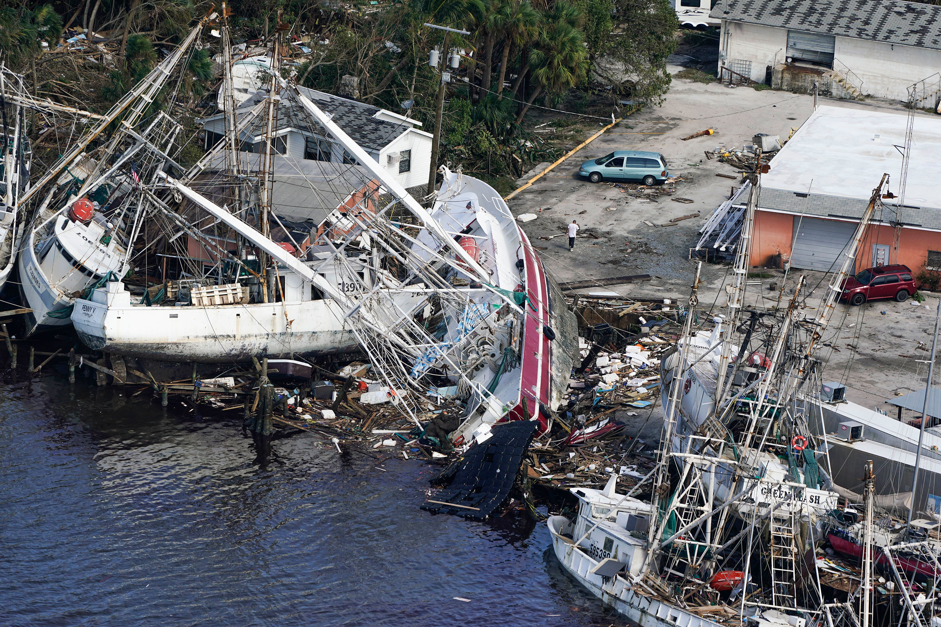 Damaged boats and debris rest against the shore in Fort Myers.