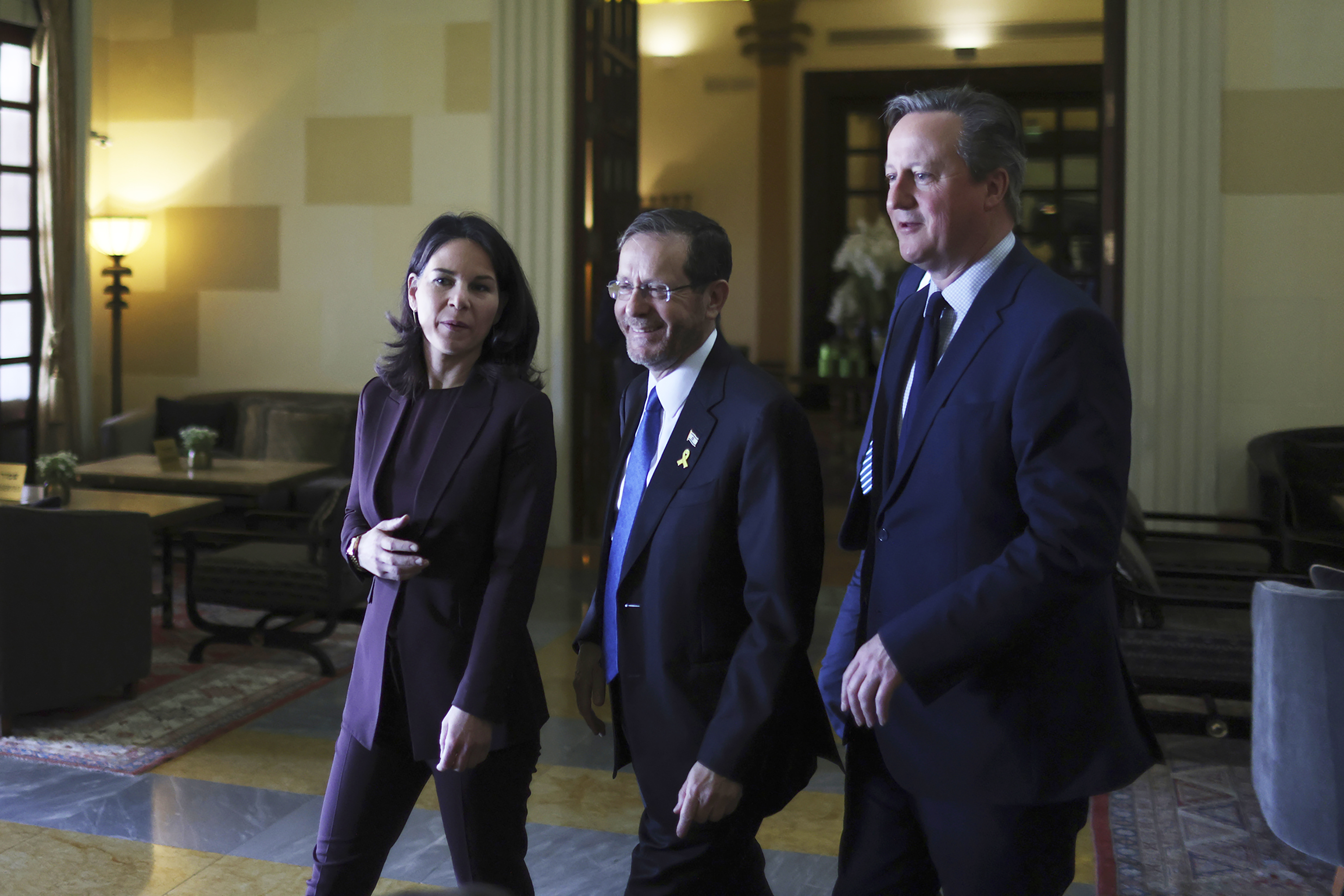 Germany's Foreign Minister Annalena Baerbock (L) and UK Foreign Secretary David Cameron (R) arrive for a meeting with Israeli President Isaac Herzog (C) at a hotel in Jerusalem on April 17.