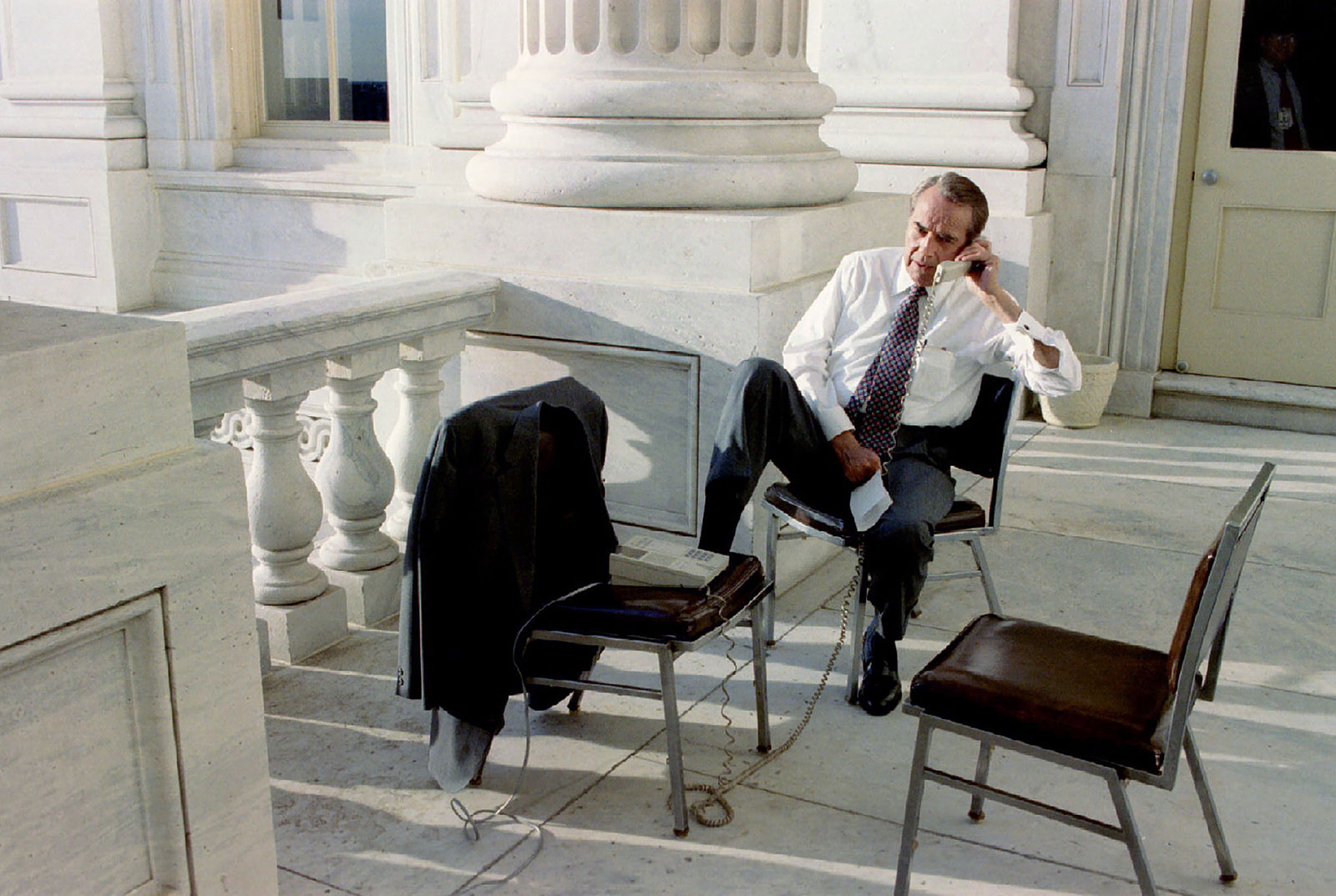 Dole works on the phone from the balcony of his office at the US Capitol in 1996.