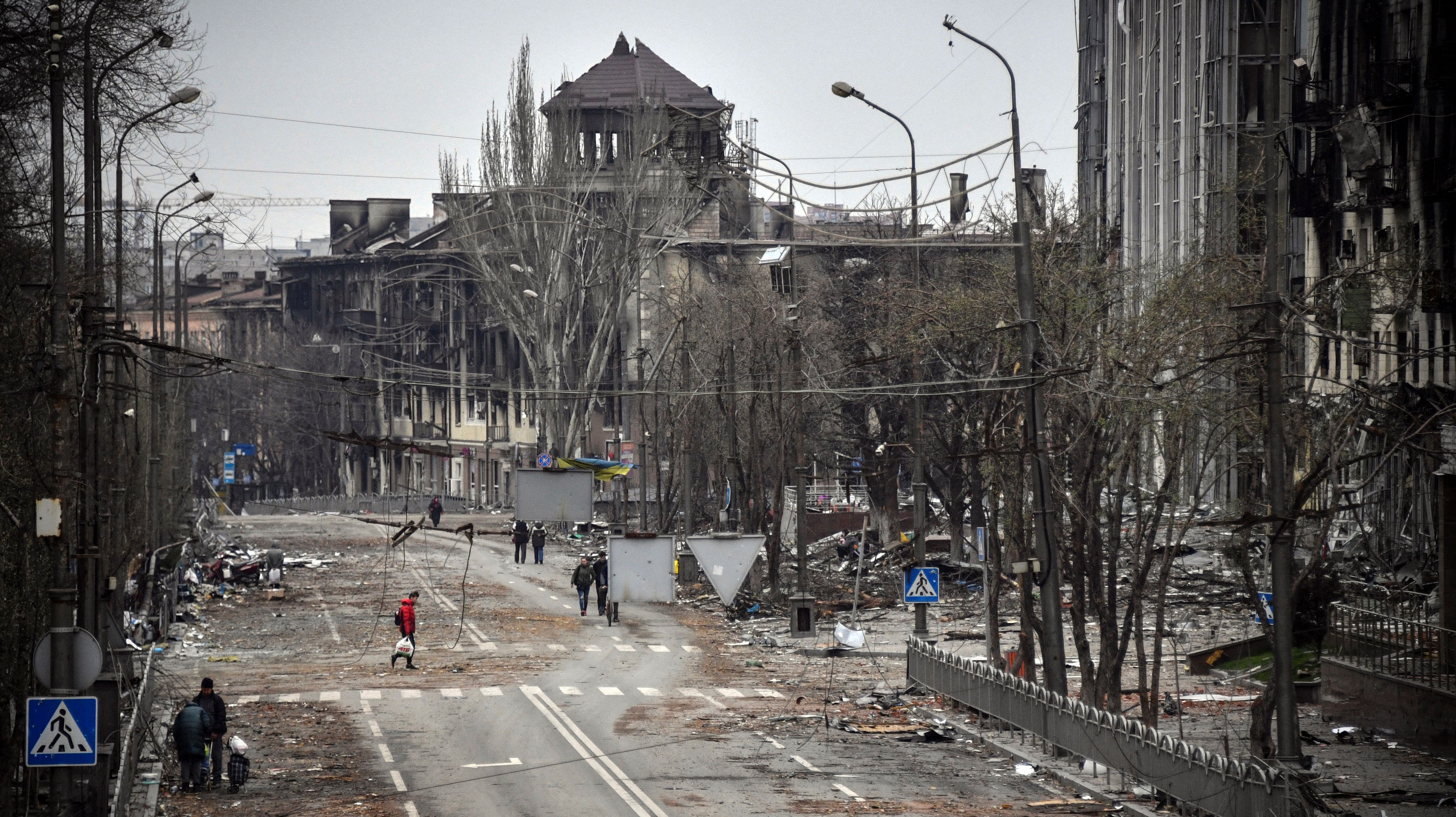 Editor's note: This photo was taken during a trip organized by the Russian military. It shows people walking down a street in Mariupol on April 12 near the site of a bombed-out theater.
