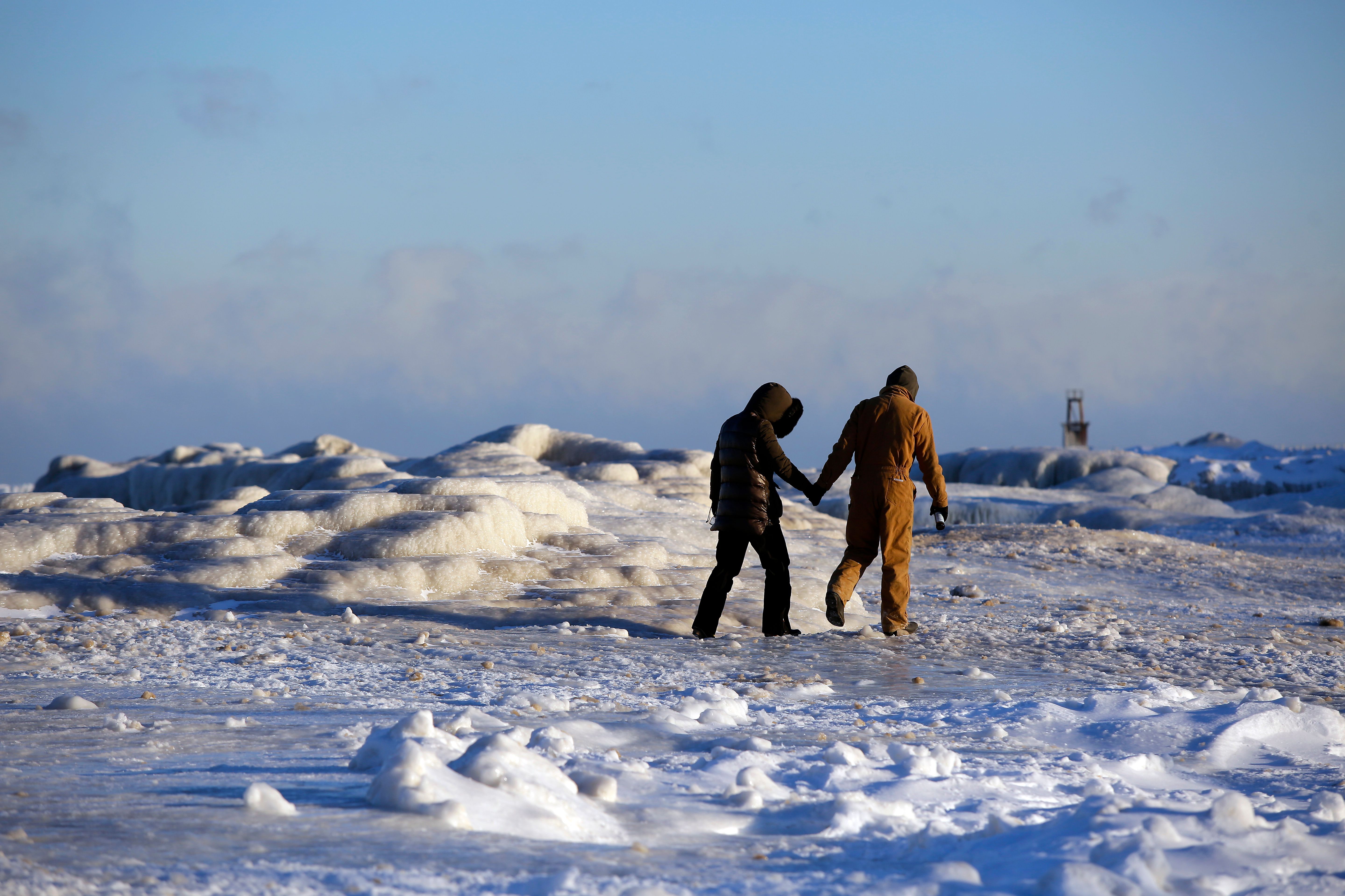 Frank Lettiere and Jelena Miletic hold hands as they view Lake Michigan's frozen shoreline in Chicago.