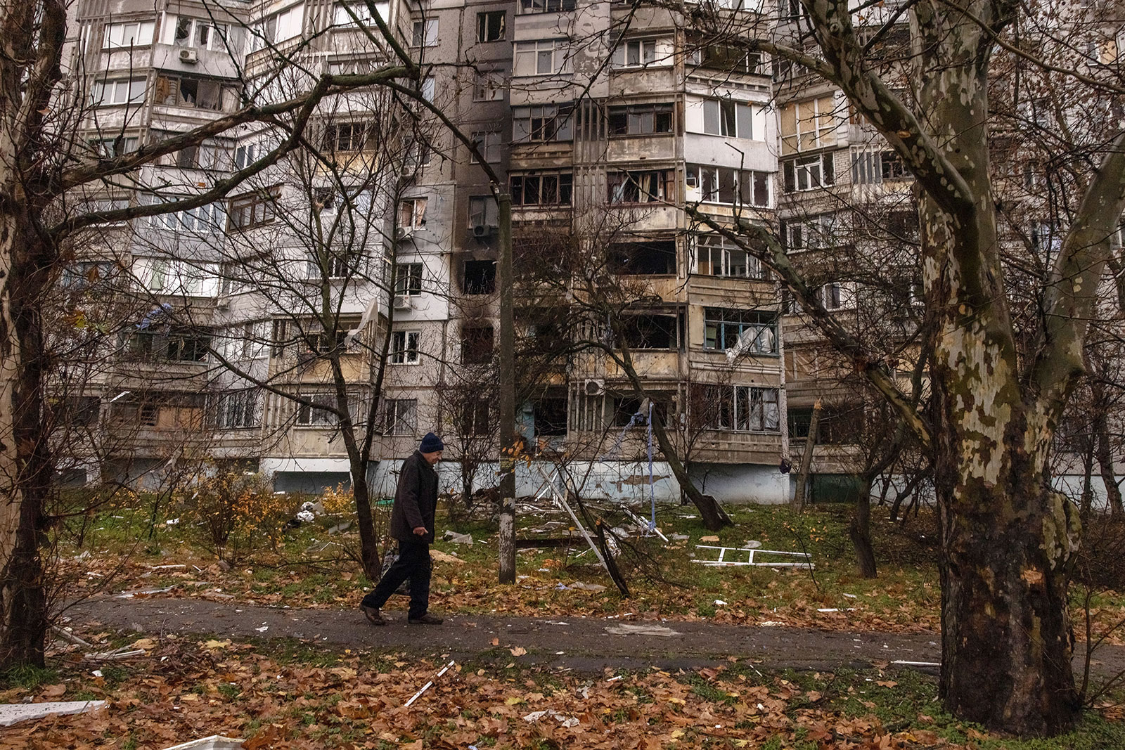 A man walks past at a residential building damaged by shelling in Kherson, Ukraine, on November 25.