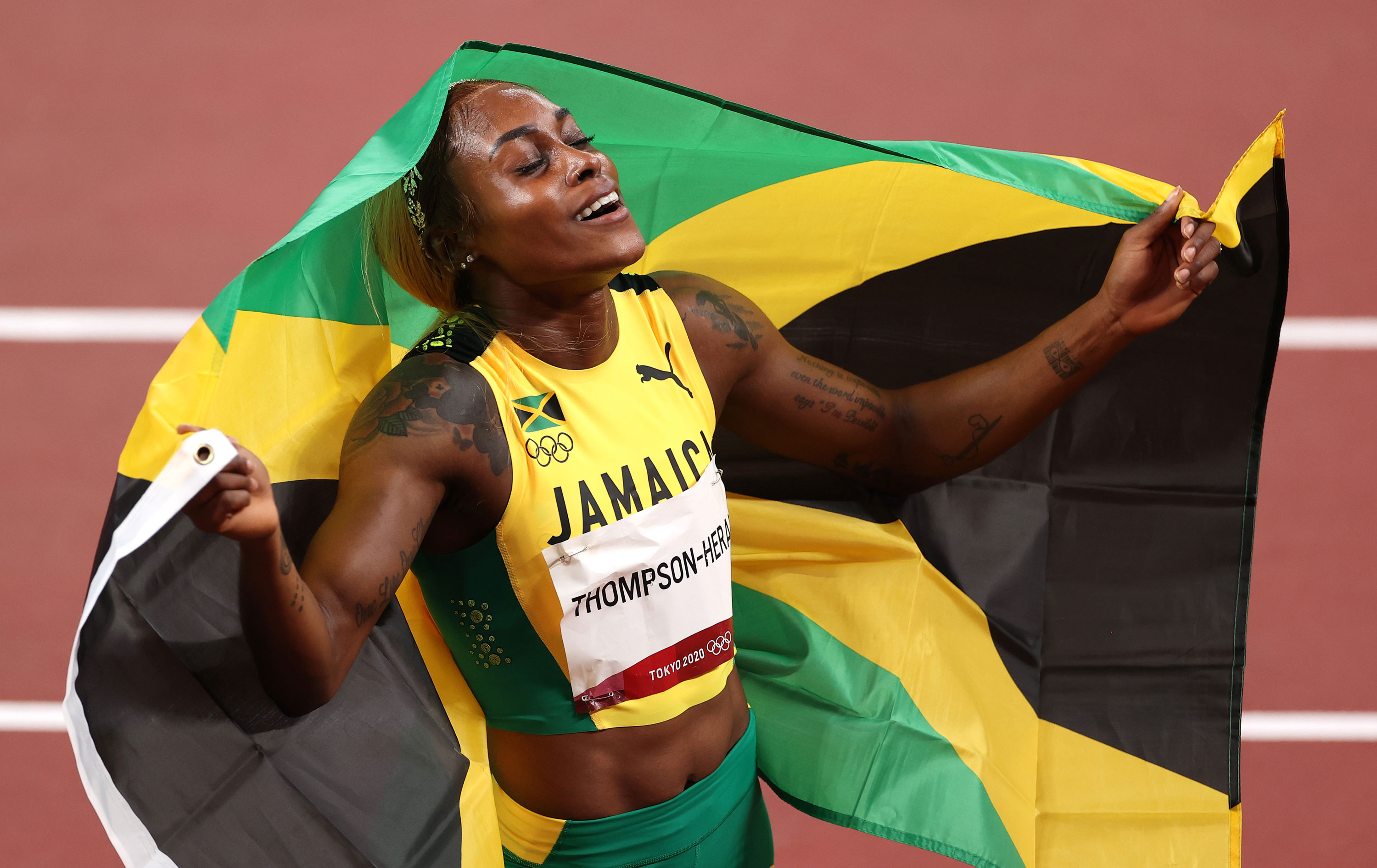 Jamaica's Elaine Thompson-Herah celebrates after winning the gold medal in the 100m final on July 31.