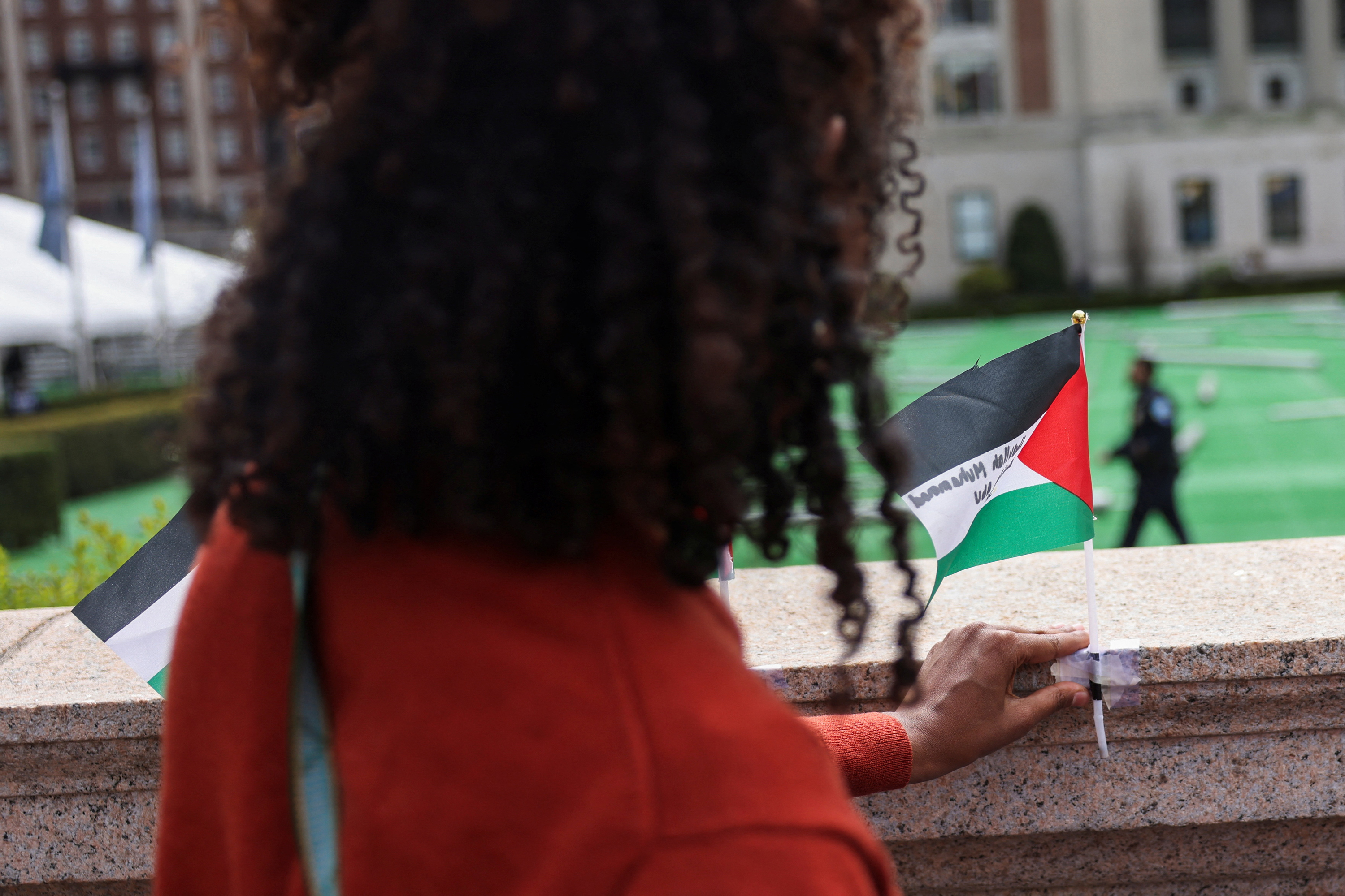 A student secures a Palestinian flag near a protest encampment on the main campus of Columbia University in New York City on April 27.