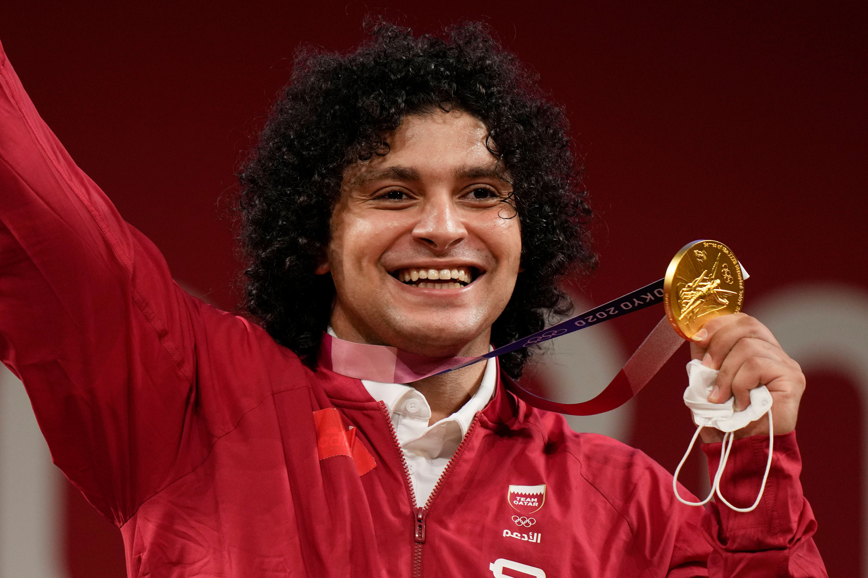 Qatar’s Fares El-Bakh celebrates on the podium after winning the gold medal in the 96kg weightlifting event on July 31. 