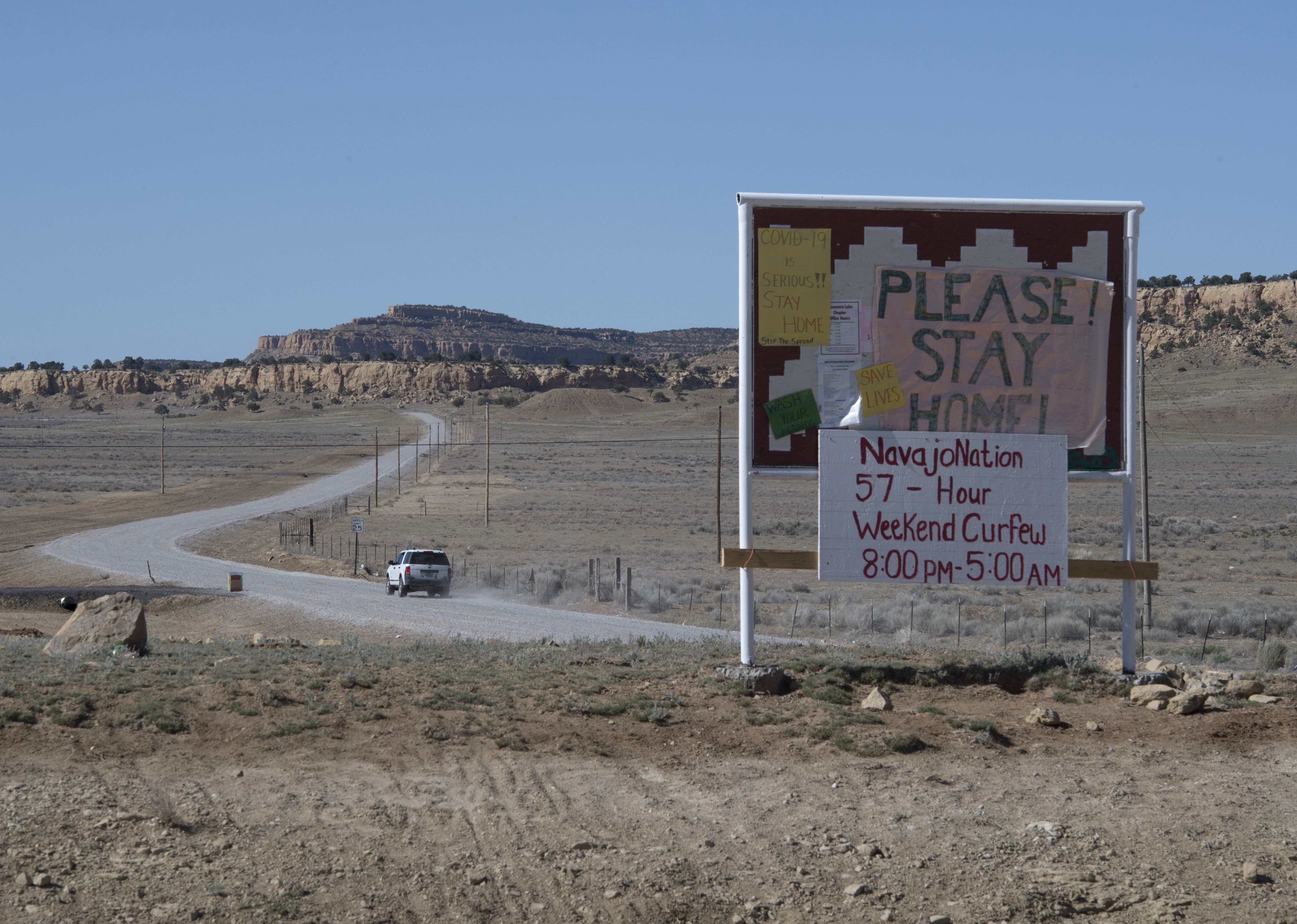 Signs seen on May 20 near Prewitt, New Mexico, alert the Navajo Nation community to a weekend curfew.