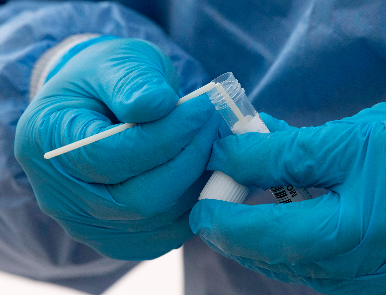 Health personnel breaks a swab to put it into the collection tube after taking a smear at a drive-in coronavirus testing station in Nuertingen, southern Germany, on November 10.