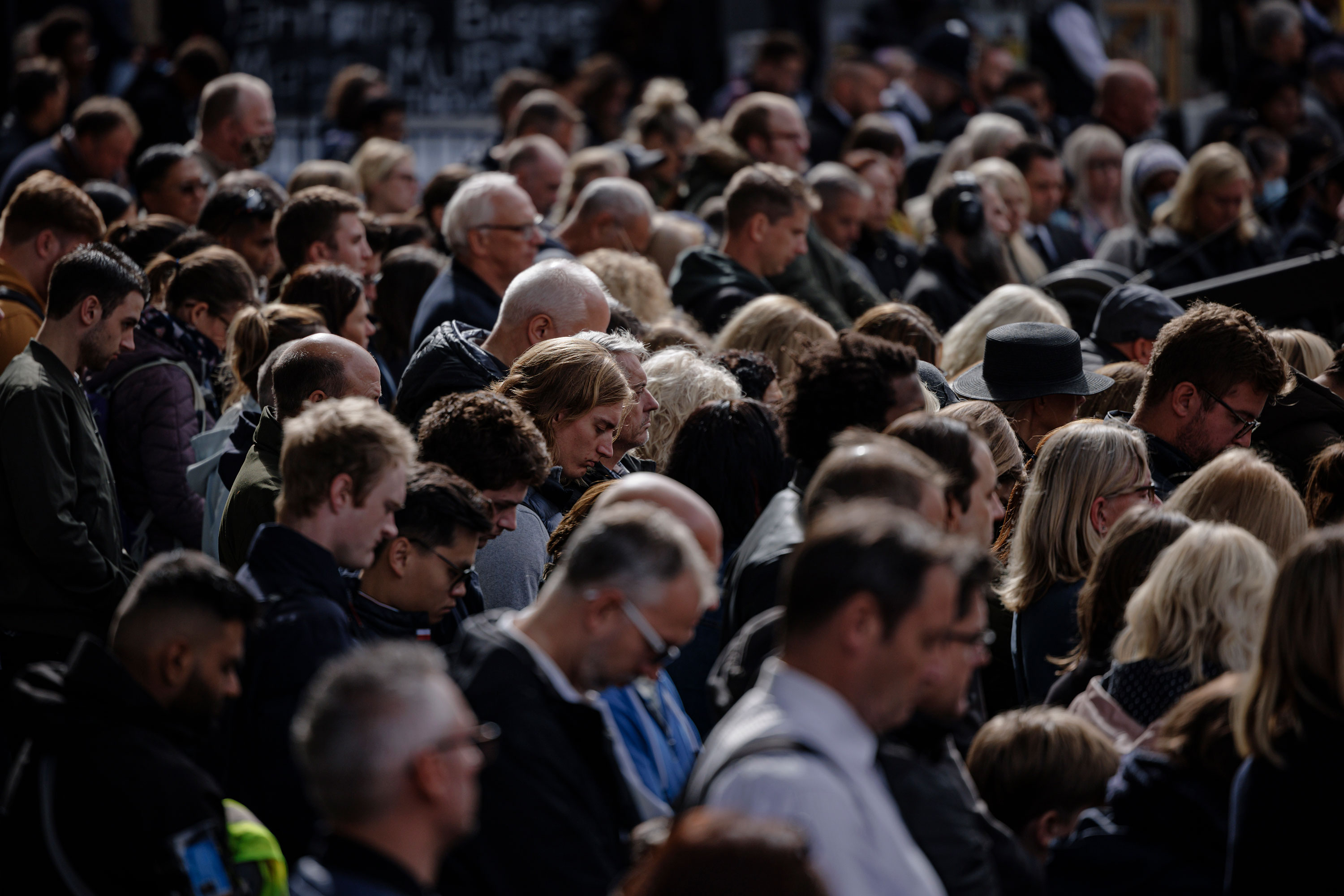 People bow their heads as they observe a two minute moment of silence at the end of Queen Elizabeth's funeral in London on Monday.