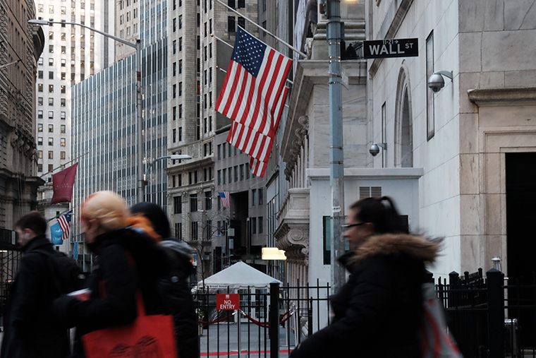 People walk by the New York Stock Exchange in the Financial District of New York City on January 26.