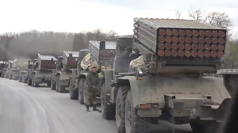 In frame taken from a video posted to social media, a long column of Russian military vehicles is seen heading from the Russian border toward the city of Izium, where Russian forces have been gathering.  The vehicles are seen moving through the city of Kupiansk in the Kharkiv region. 