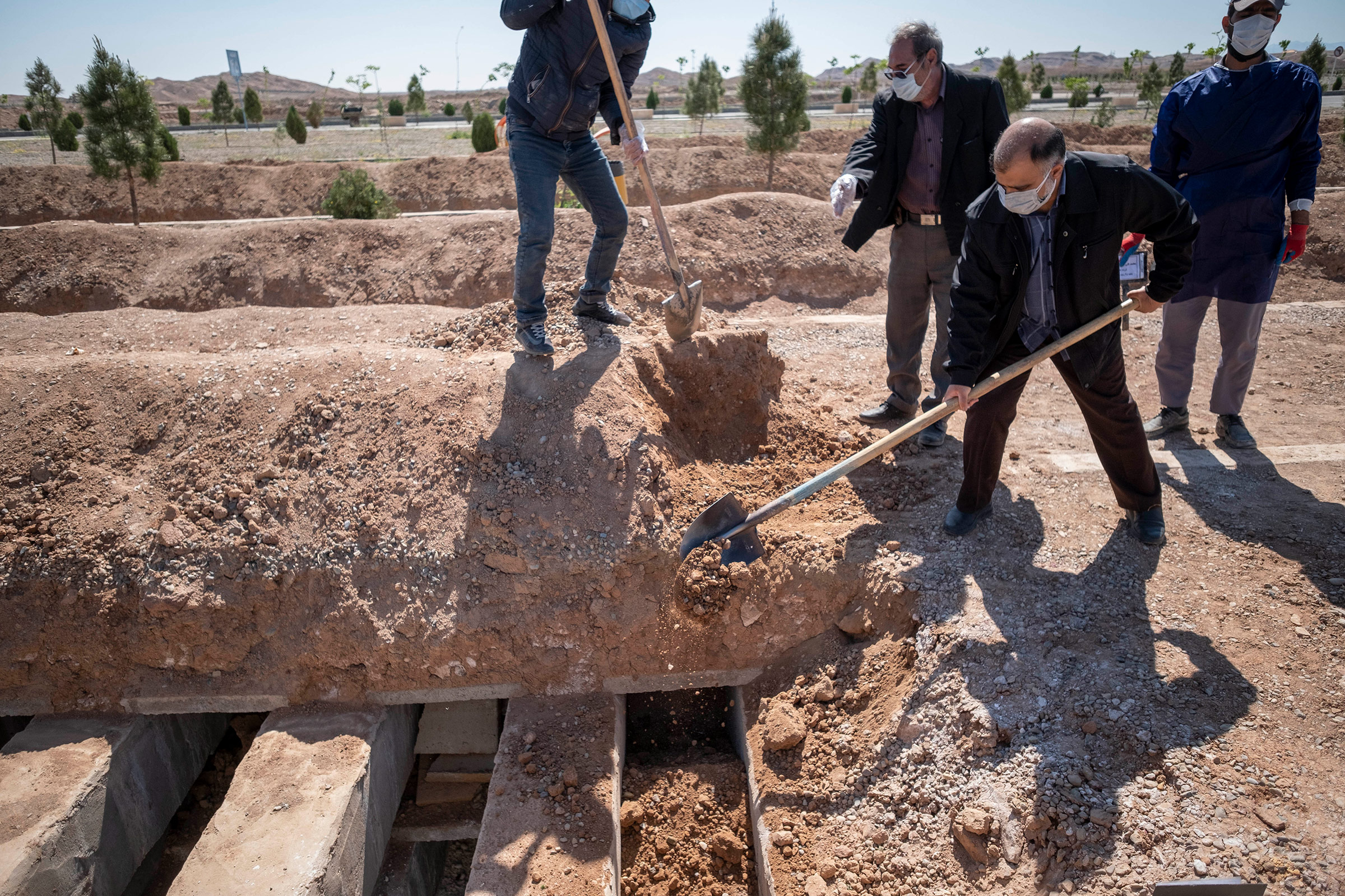 Relatives of a Covid-19 victim cover the body with soil at Benhesht-e-Masoumeh cemetery in Qom, Iran, on April 4. 