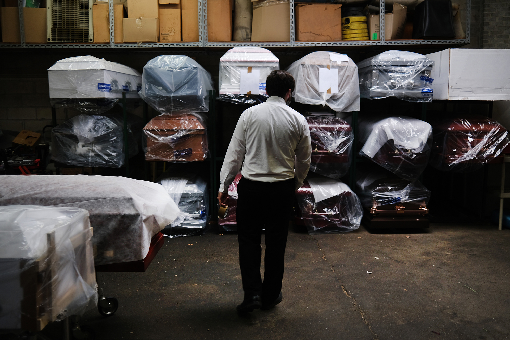 A funeral home worker tends to the inventory of pre-sold caskets at a funeral home on April 29, 2020 in New York City. 