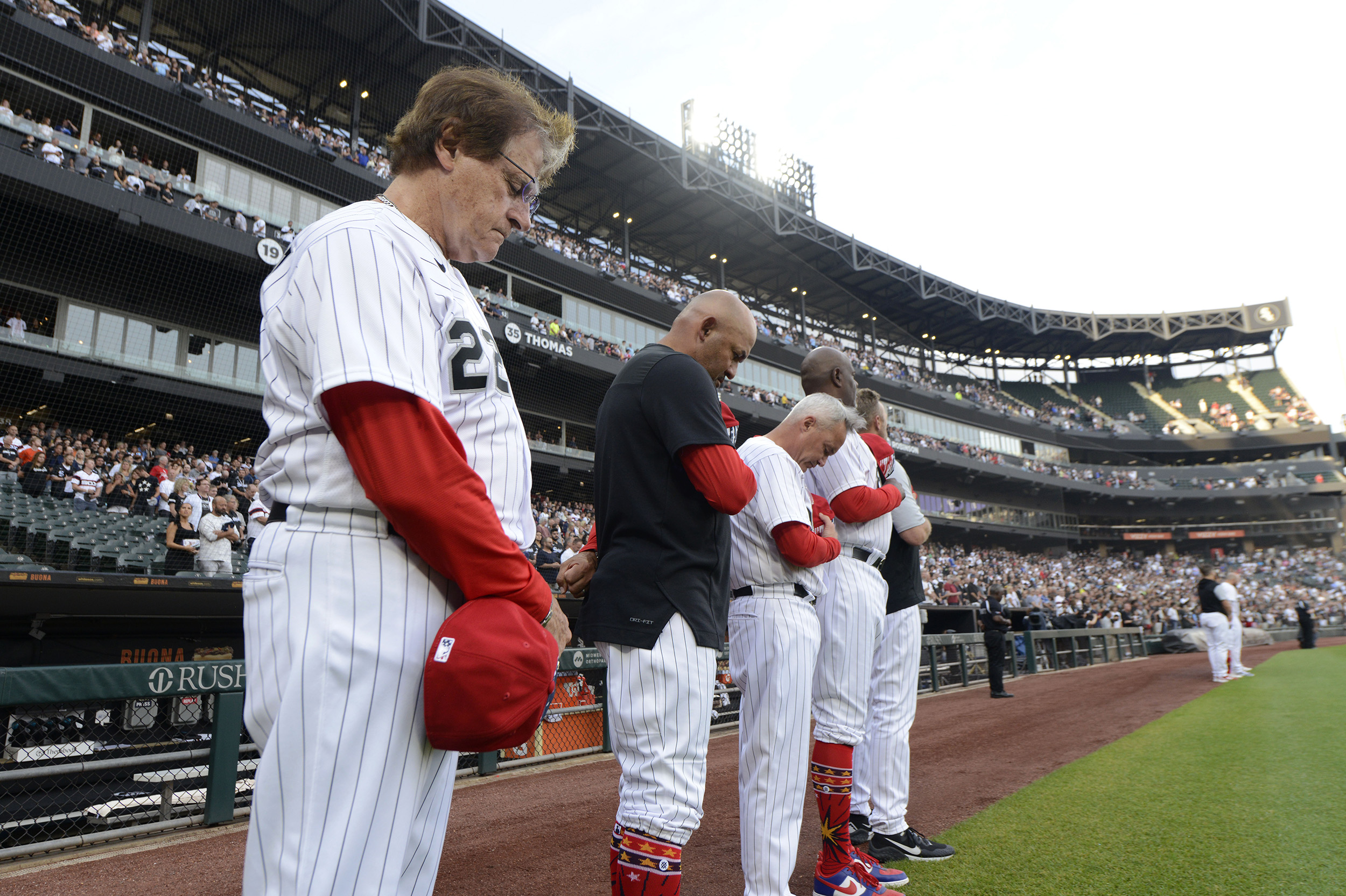 Chicago White Sox manager Tony La Russa, left, and his coaches bow their heads during a moment of silence at Guaranteed Rate Field for the victims of a Fourth of July parade shooting in nearby Highland Park, Ill., on July 4.