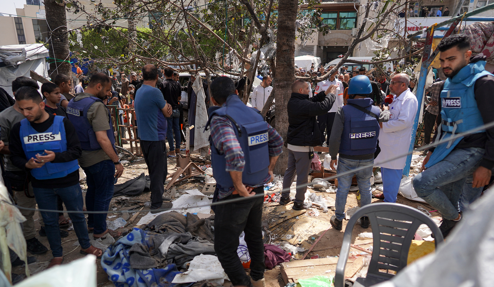 Palestinians and journalists check the damage after an Israeli strike at a makeshift camp for displaced people in front of the Al-Aqsa Martyrs Hospital in Deir al-Balah, Gaza, on March 31. 