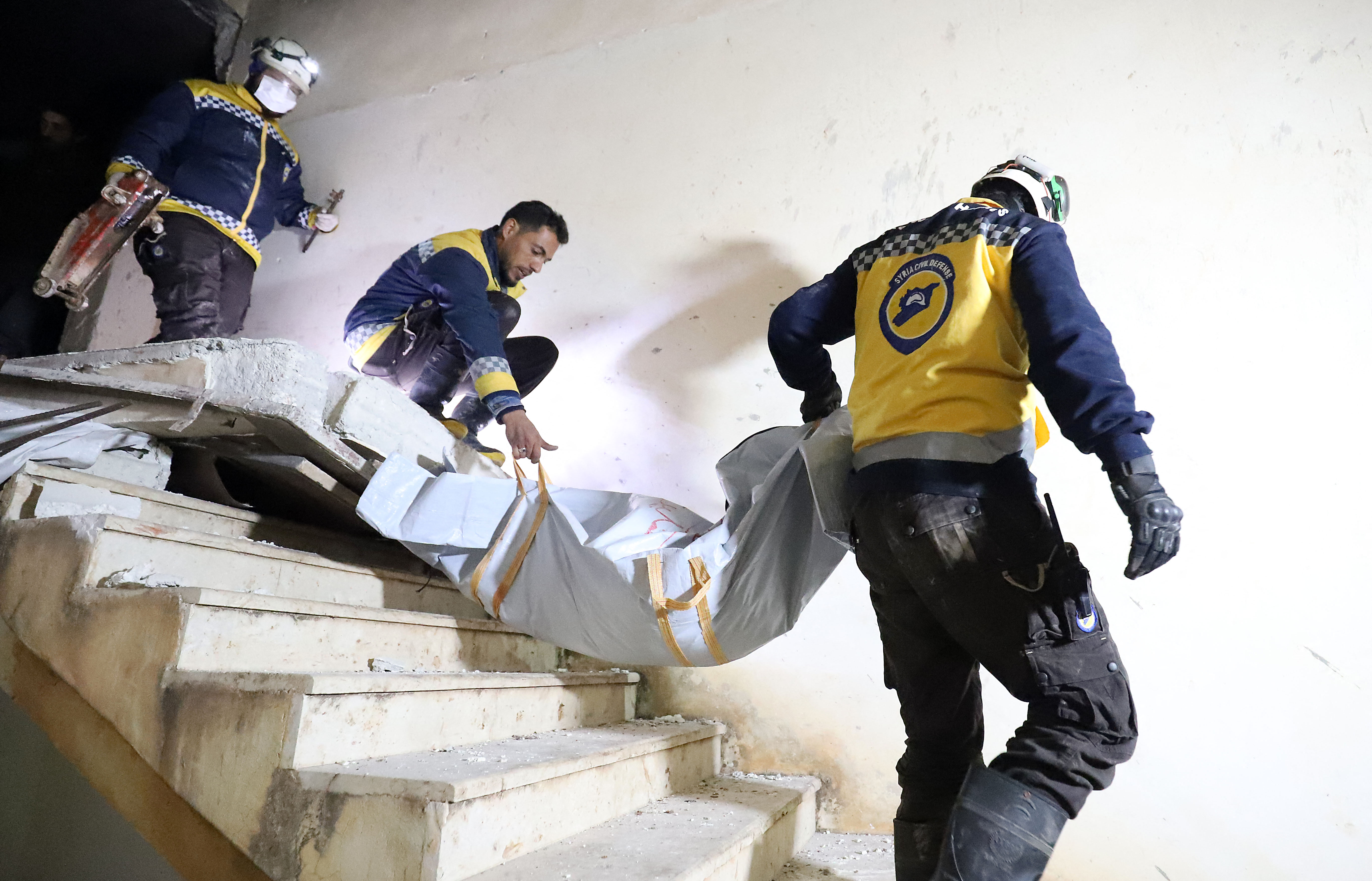 Syrian Civil Defence volunteers evacuate a body from a house in northwestern Syria on February 3 following an overnight raid by US special operations forces against suspected jihadists.