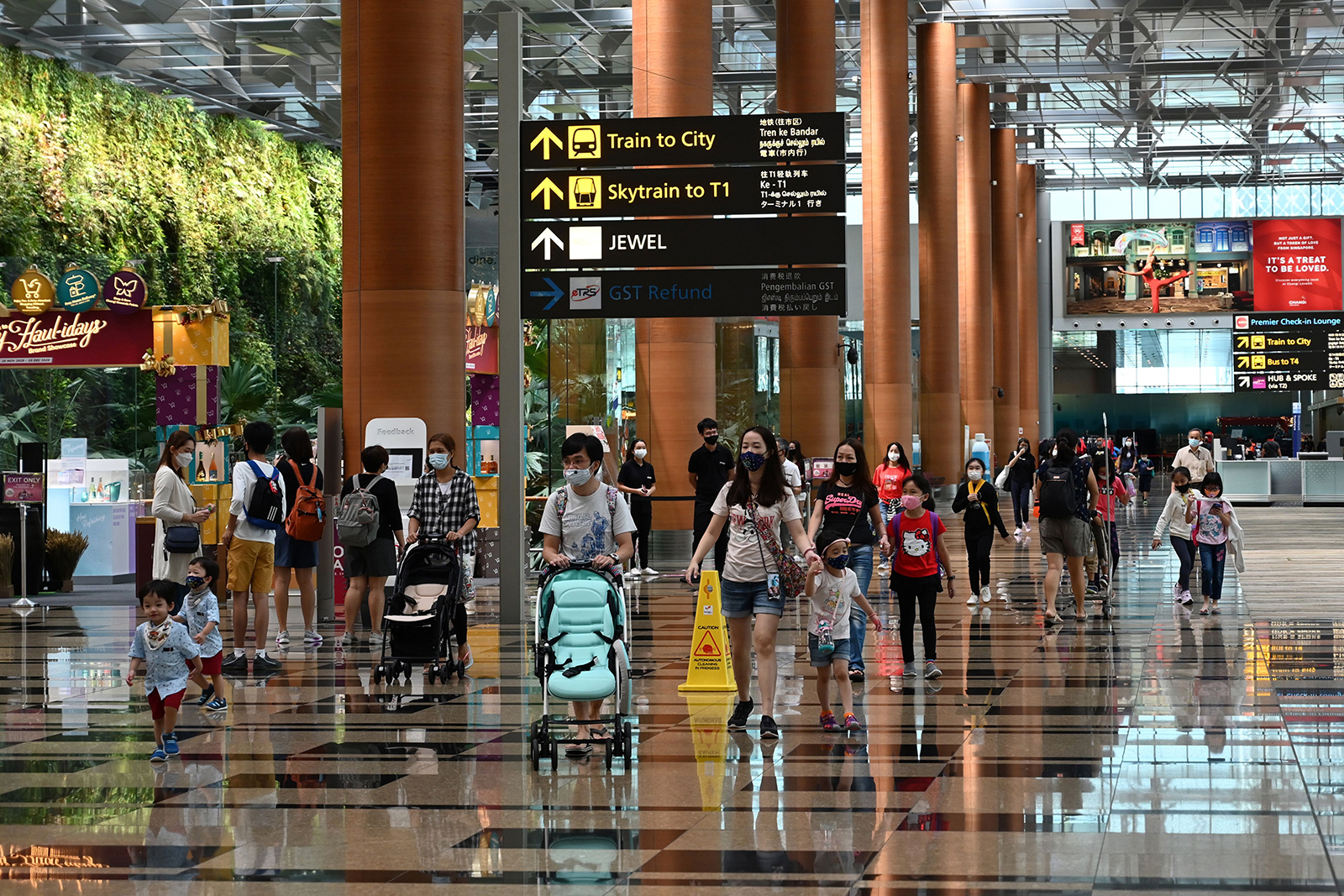 Visitors walk through a terminal of the Changi International Airport in Singapore, on December 7.