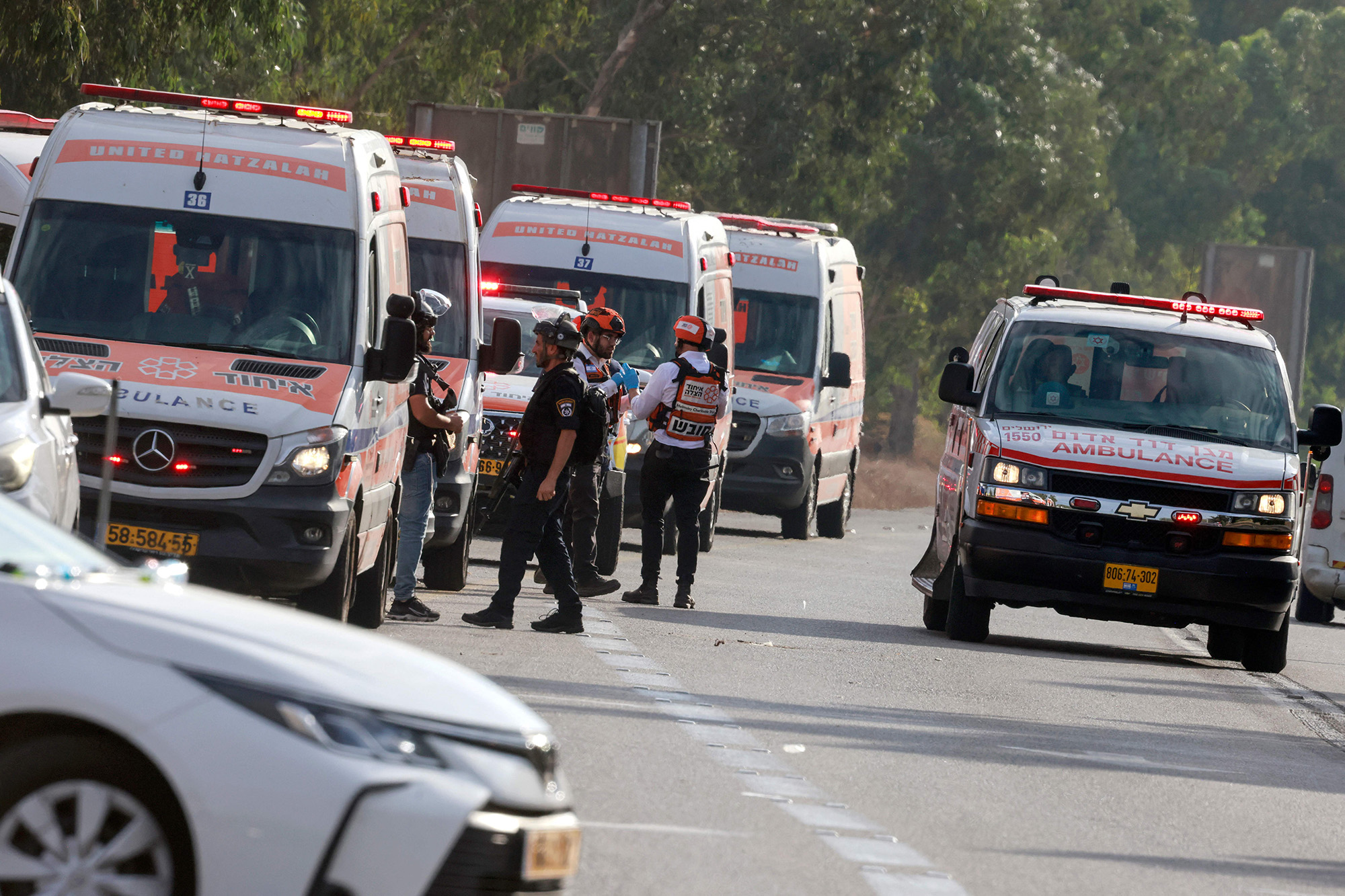 Israeli rescue teams wait next to ambulances parked just outside the southern city of Sderot, Israel, to evacuate the wounded on October 7.