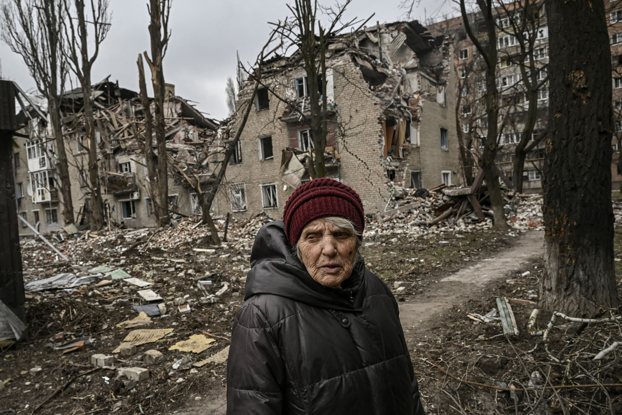 An eldery woman stands in front of a destroyed apartment building in the city of Avdiivka, Donetsk Oblast, Ukraine, on March 18.