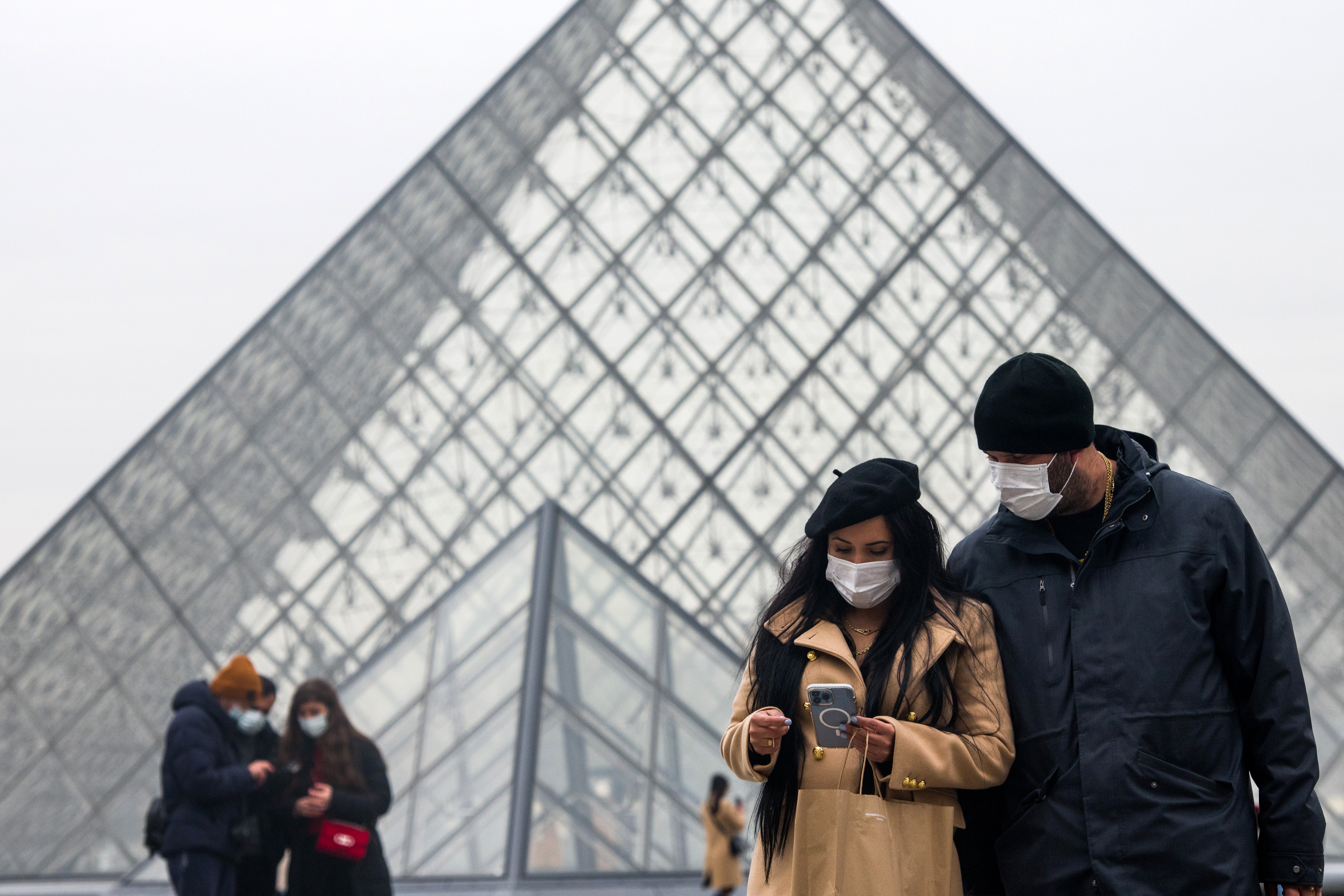 Visitors wear protective masks at the Louvre Museum in Paris, France, in this file photo dated January 12, 2022. 
