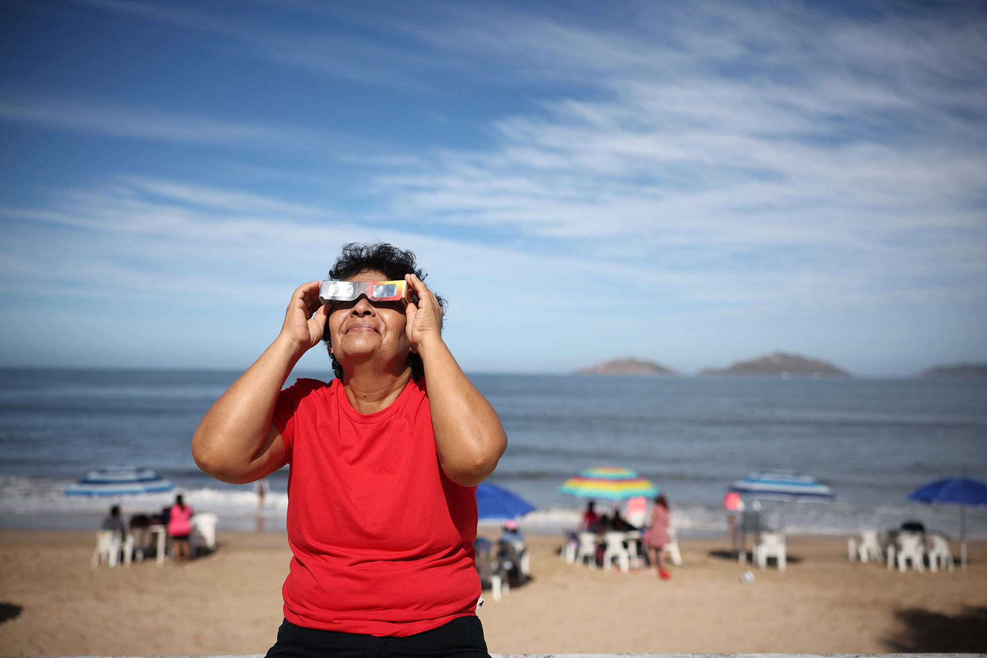 A woman puts on her glasses to see the eclipse in Mazatlan, Mexico, on April 08. 