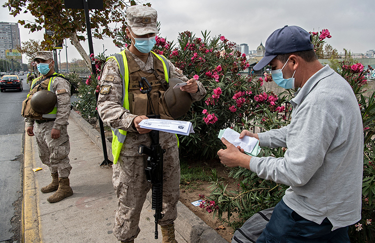 A soldier checks a pedestrian's ID at a checkpoint in Santiago, on March 25, as a new quarantine began Chile, due to a sharp increase in new cases of covid-19.