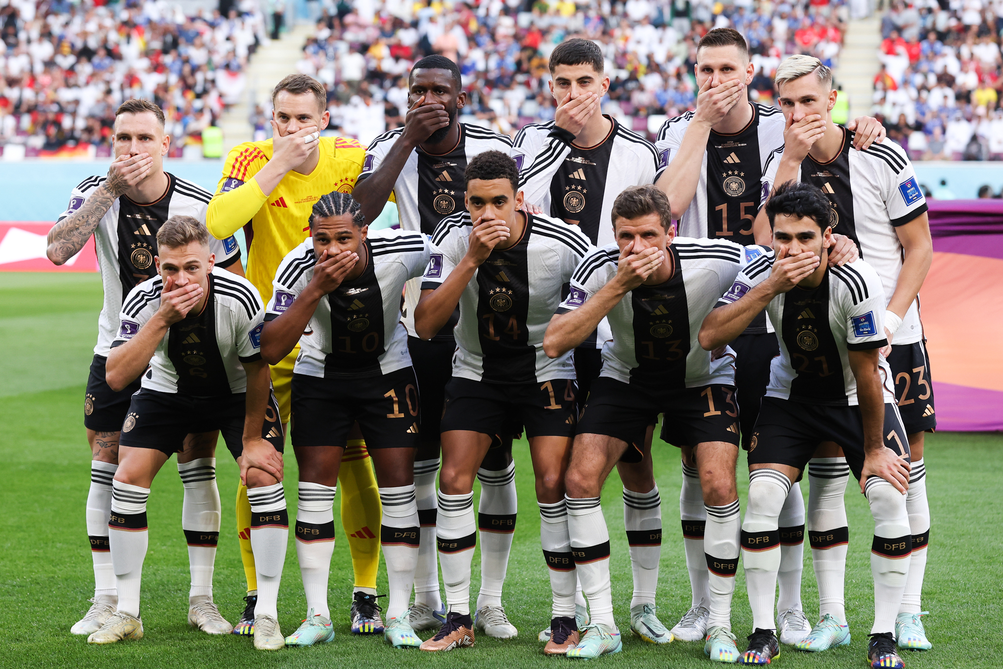 Germany's players cover their mouths as they pose for a team photo before their match against Japan at Khalifa International Stadium in Doha, Qatar on Wednesday.