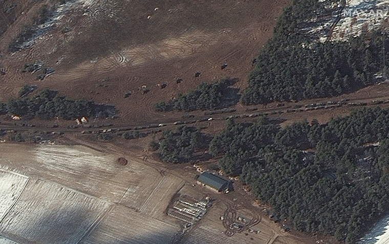 In Berestyanka, 10 miles west of the airbase, a number of fuel trucks and what Maxar says appears to be multiple rocket launchers are seen positioned in a field near trees.
