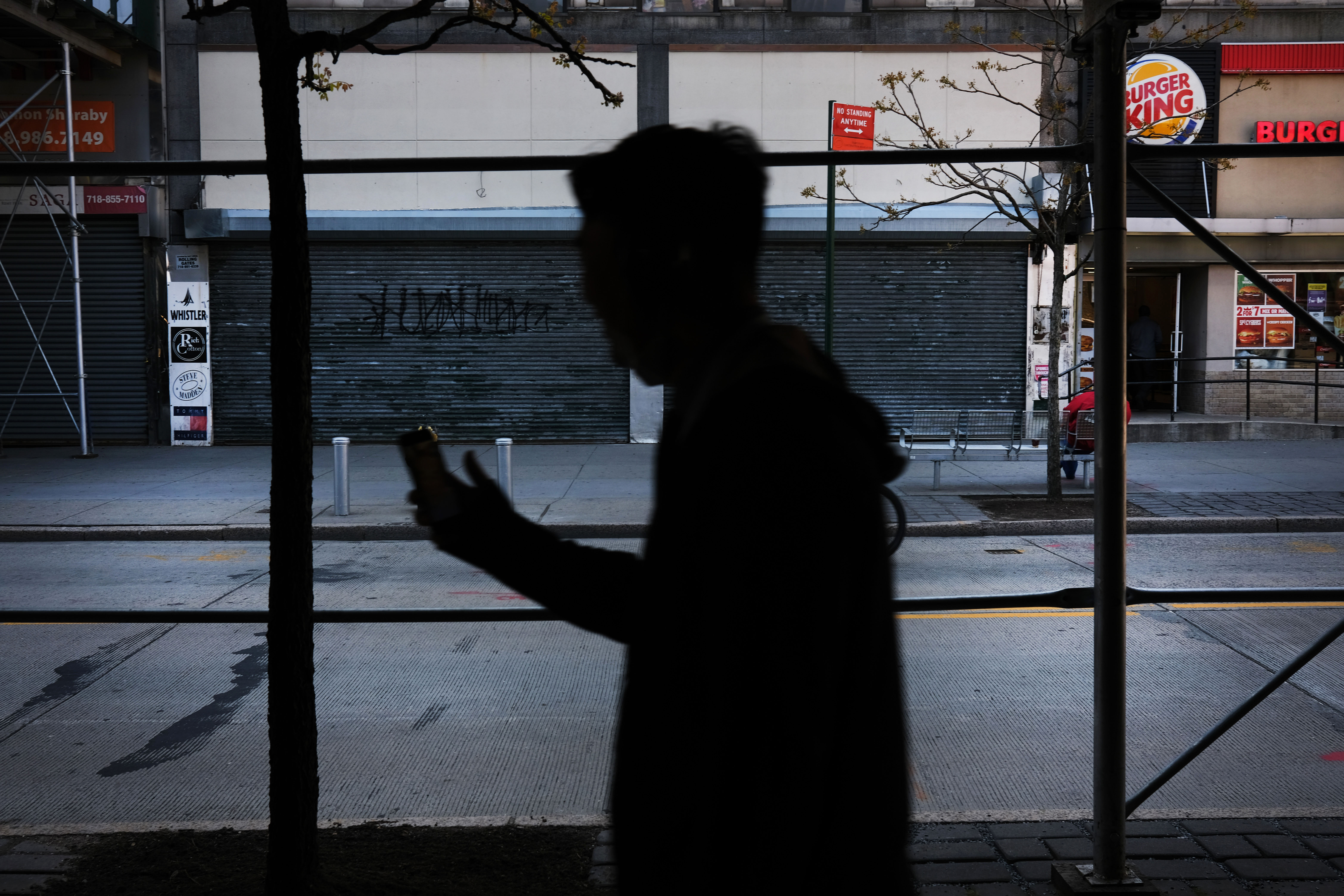 A person walks by shuttered businesses in Brooklyn, New York, on May 12.