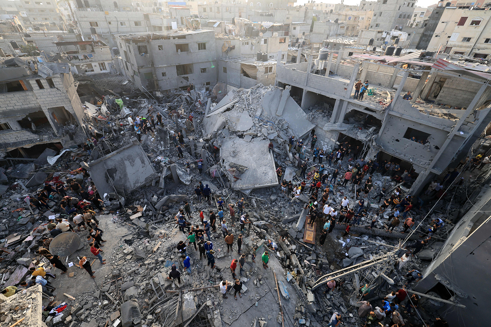 People stand in the rubble of the Al-Maghazi refugee camp in Deir Al-Balah, Gaza, on November 5. 