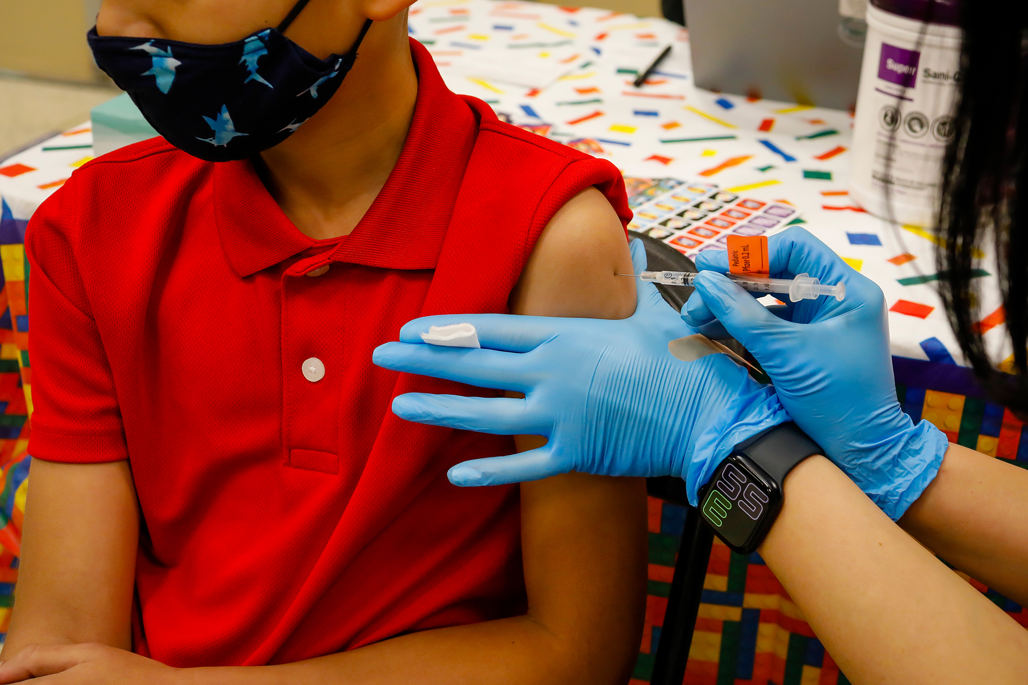 A child receives a dose of the Pfizer-BioNTech COVID-19 vaccine at an elementary school vaccination site for children ages 5 to 11-year-old in Miami, Florida, U.S., on Monday, November 22, 2021. 