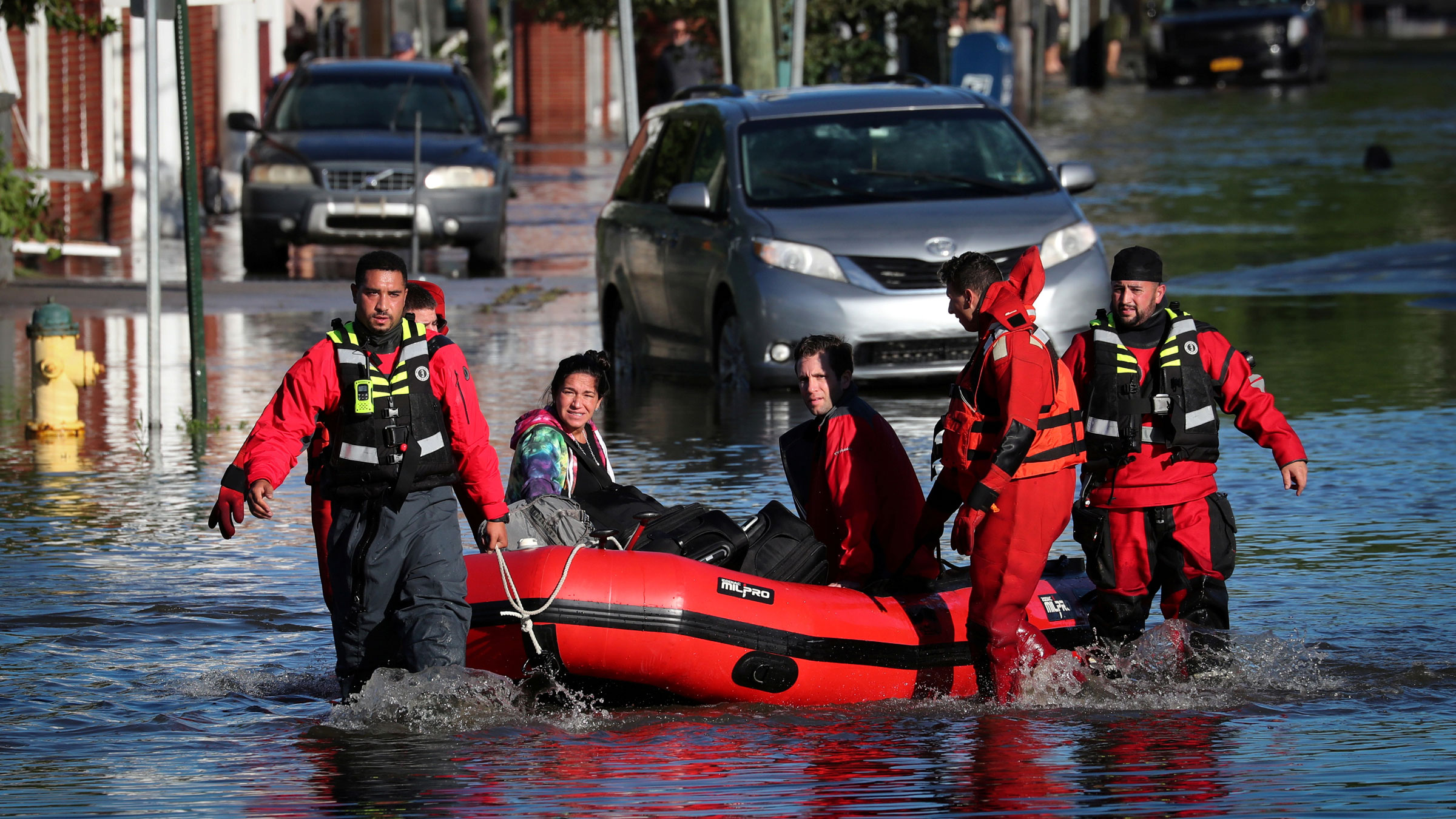 First responders pull local residents in a boat in Mamaroneck, New York, on Thursday.