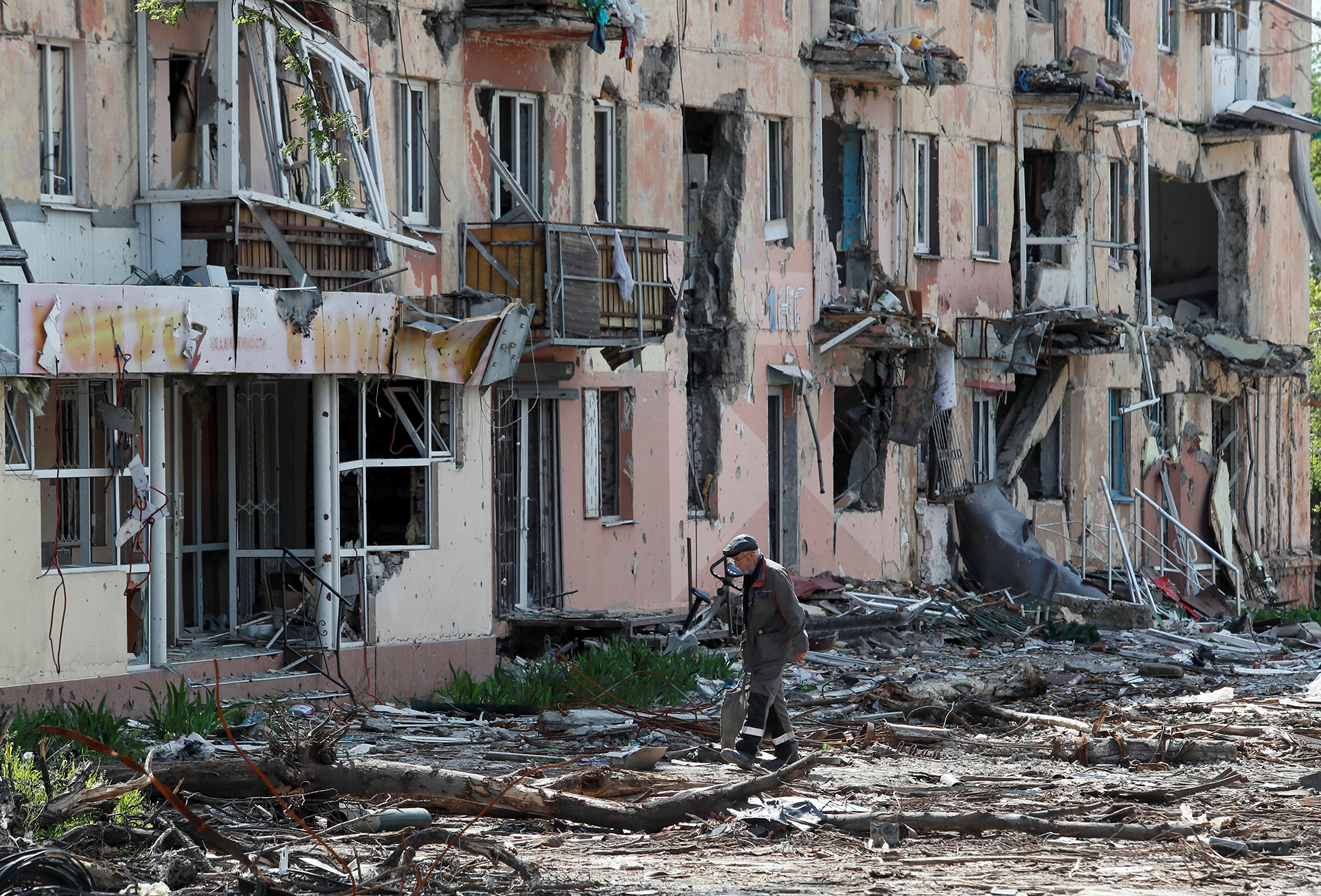 Mieszkaniec przechodzi obok zniszczonego budynku w Mariupolu 20 maja.