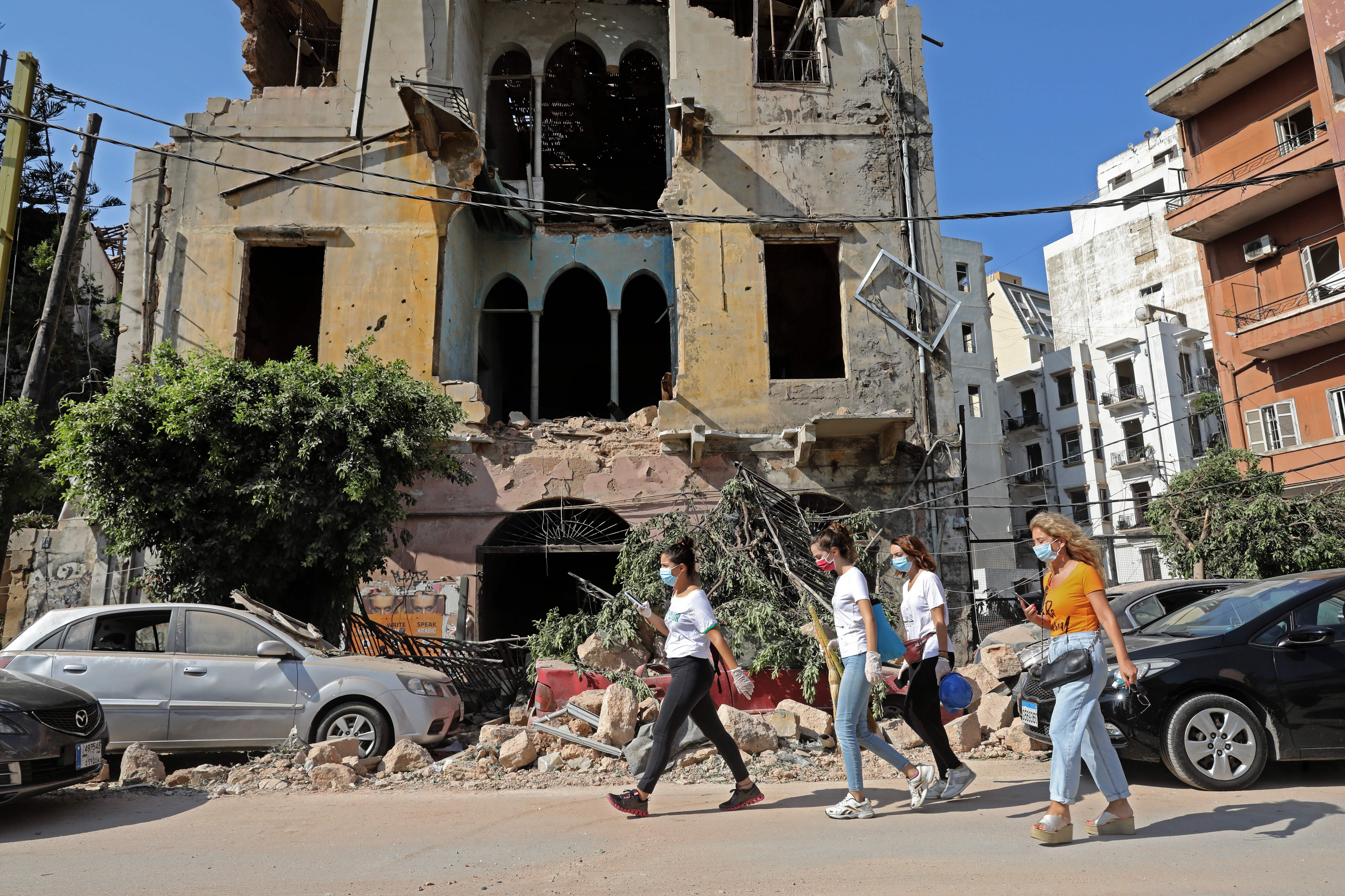 People walk past a damaged building on August 5.
