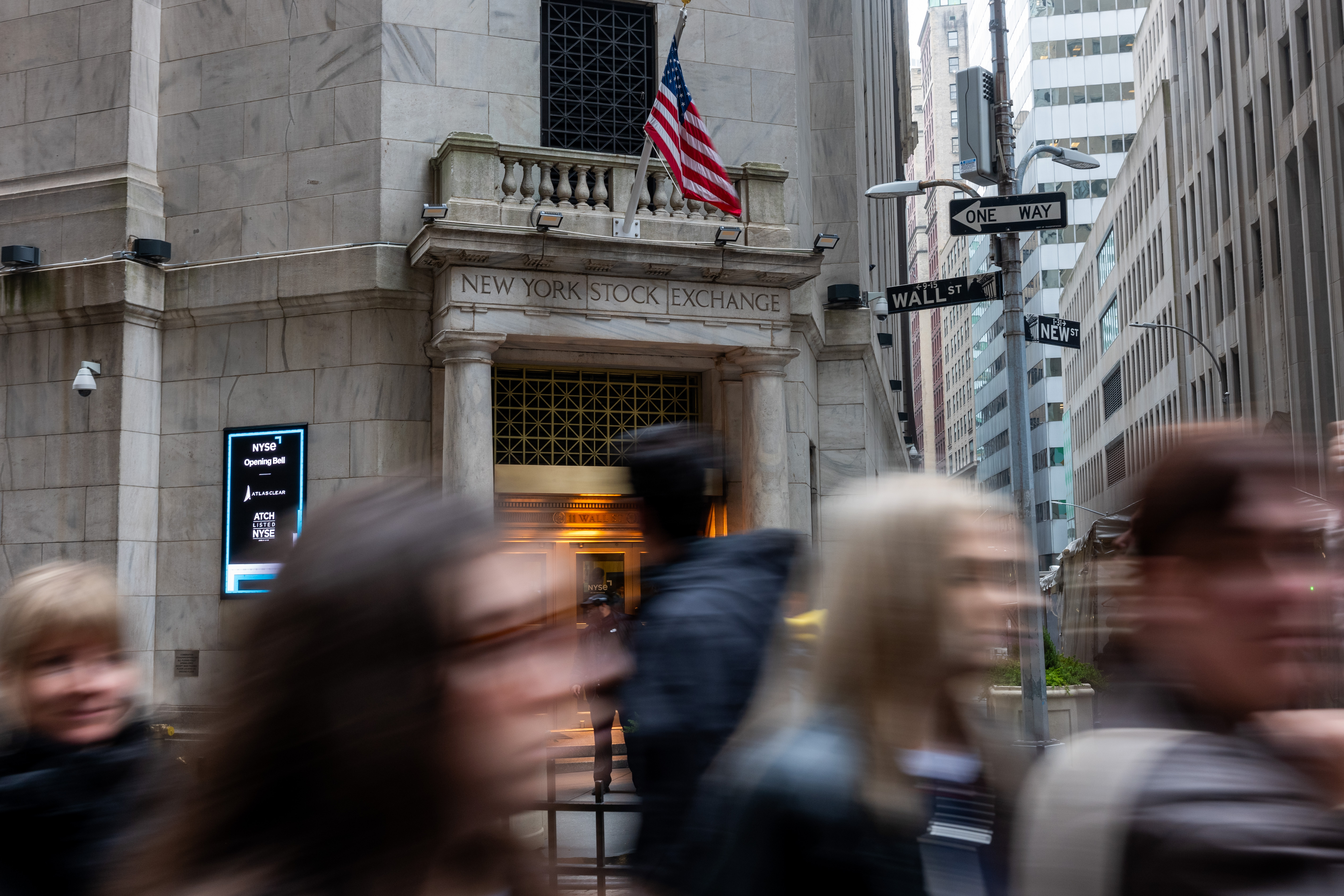 People walk by the New York Stock Exchange on March 6.