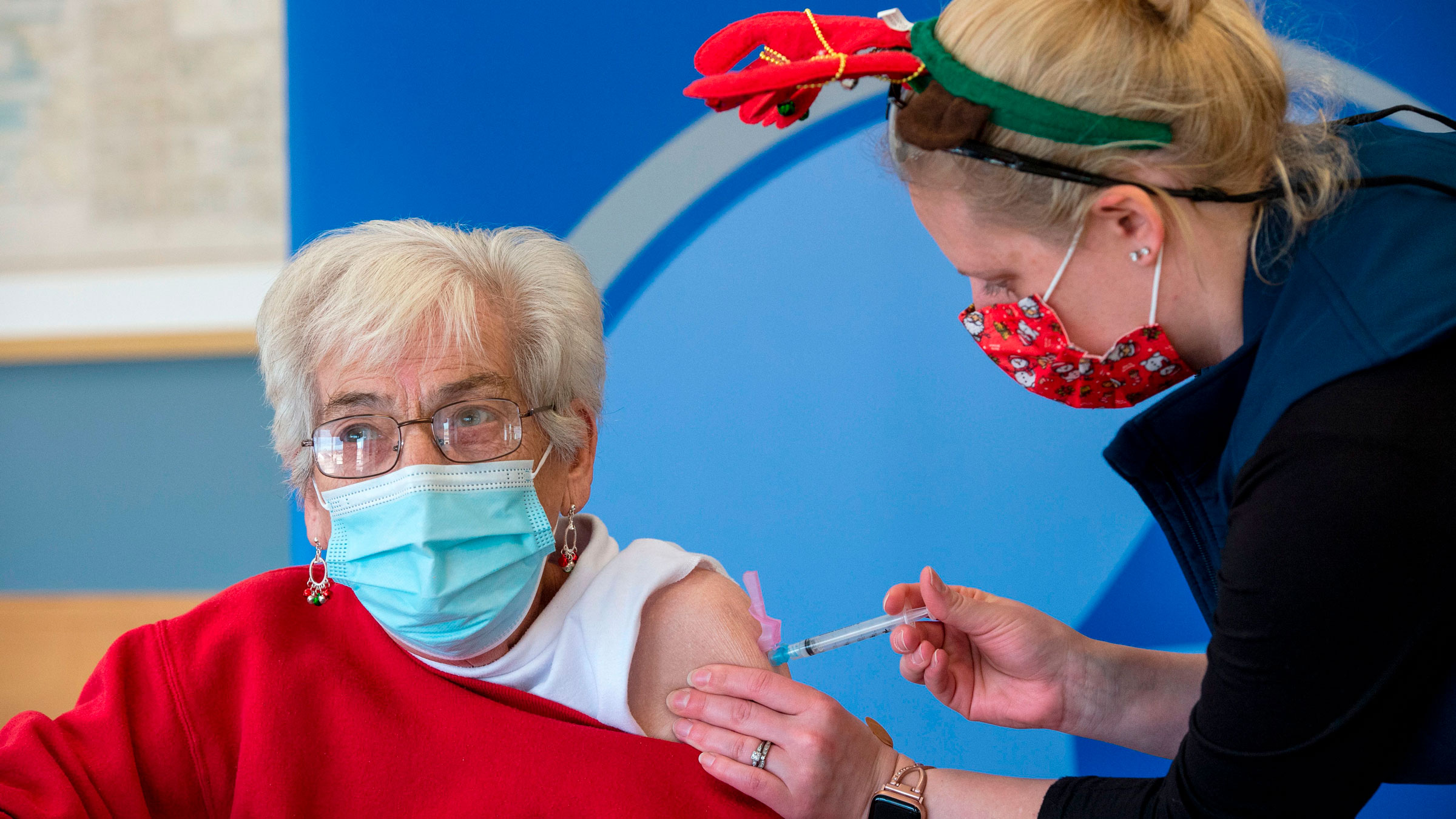 Nurse Courtney Senechal inoculates Phyllis Fischer with a Covid-19 vaccine in Boston.