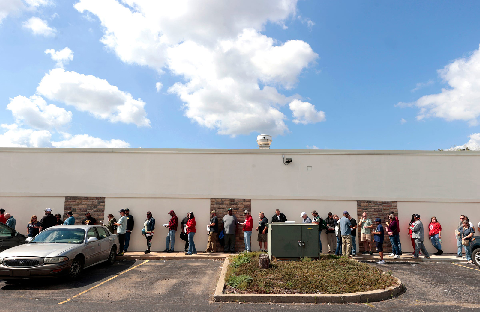 Ford Motor Company Michigan Assembly plant workers, part of Local 900 in Wayne, stand in a long line on Friday that wraps around their union hall across the street from the plant to register to strike and receive their weekly strike pay.