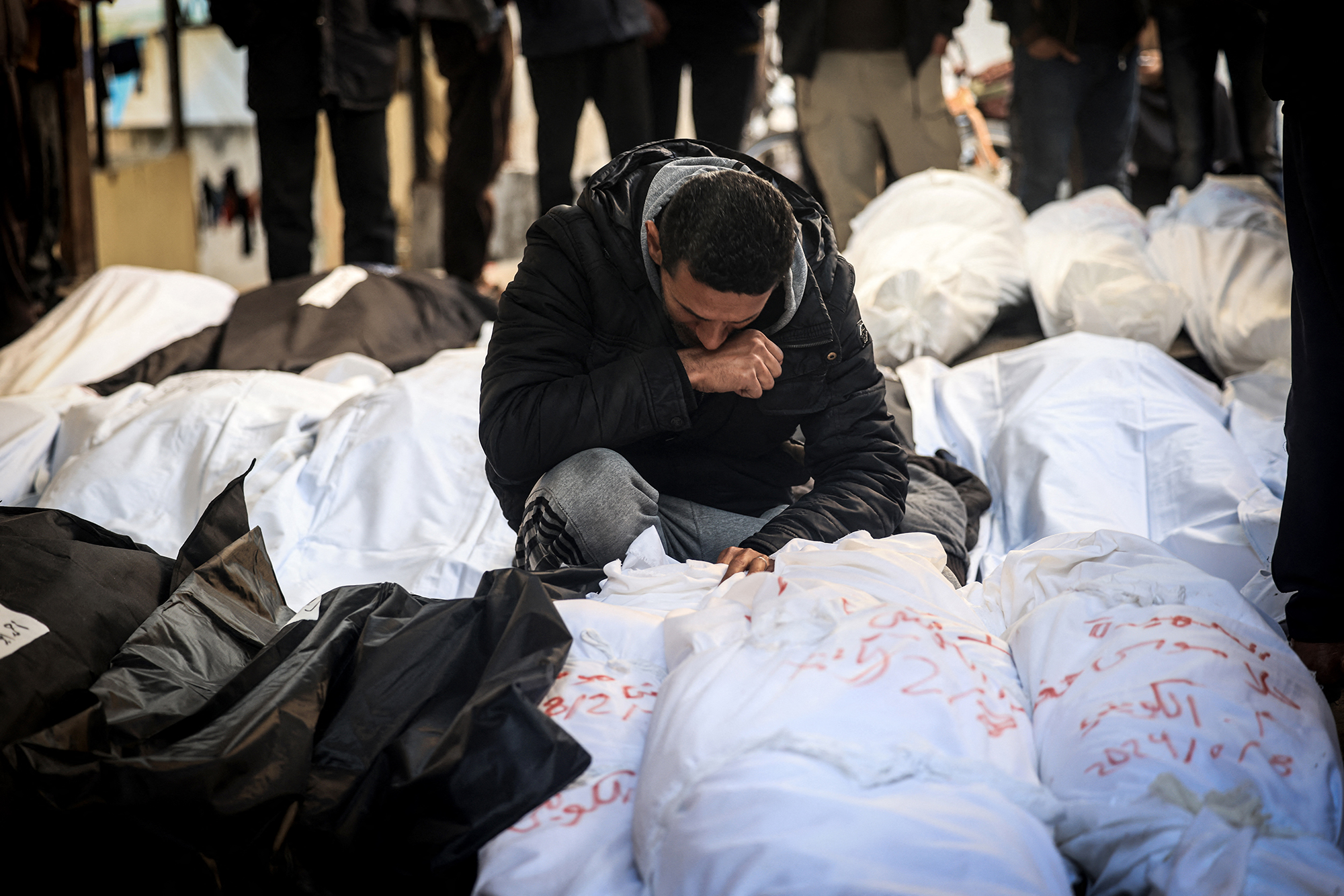 A Palestinian man mourns over shrouded bodies of relatives killed in an overnight Israeli bombardment in southern Gaza on February 8.