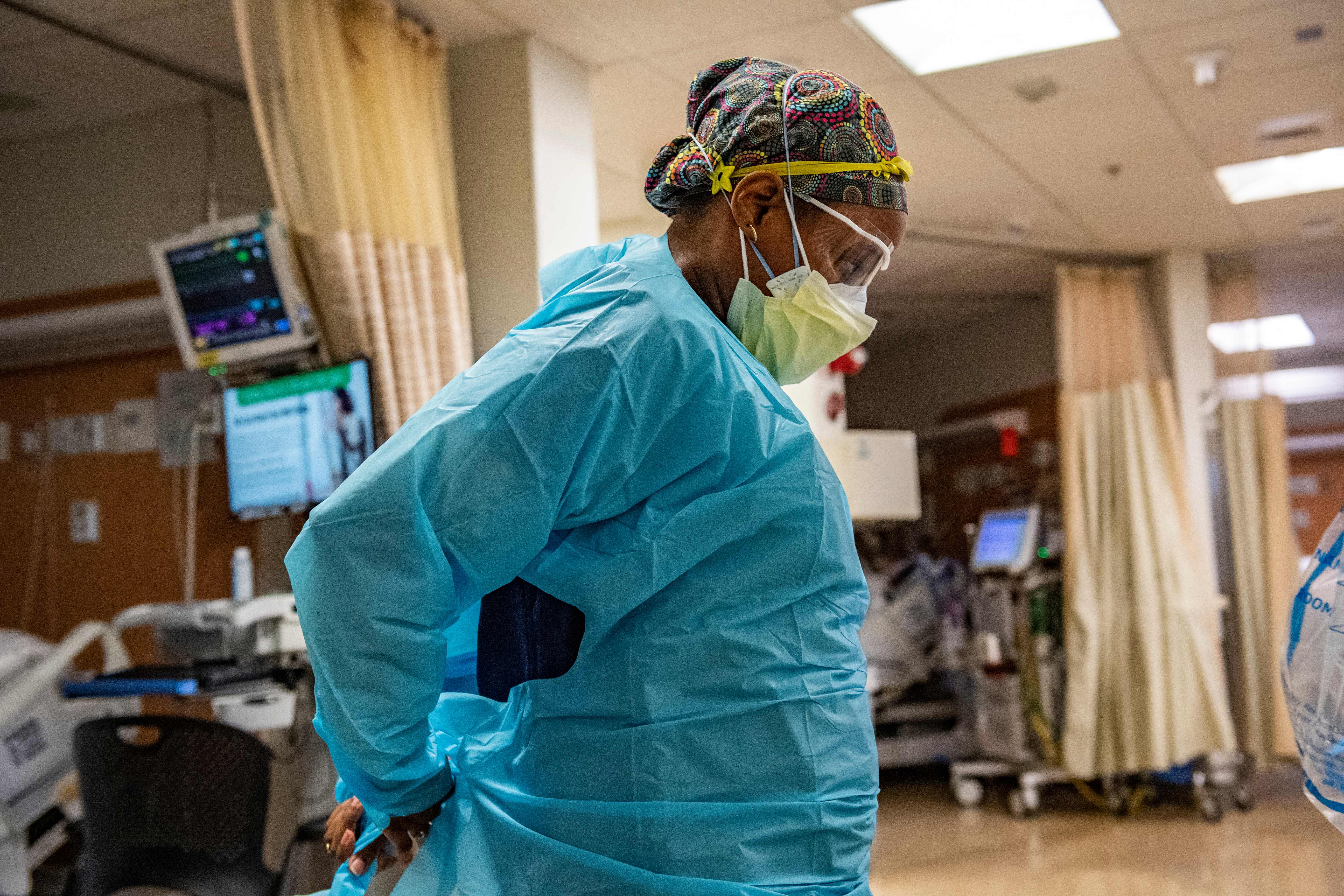 A medical workers puts on PPE before entering a negative pressure room with a Covid-19 patient in the ICU ward at UMass Memorial Medical Center in Worcester, Massachusetts on January 4, 2022.